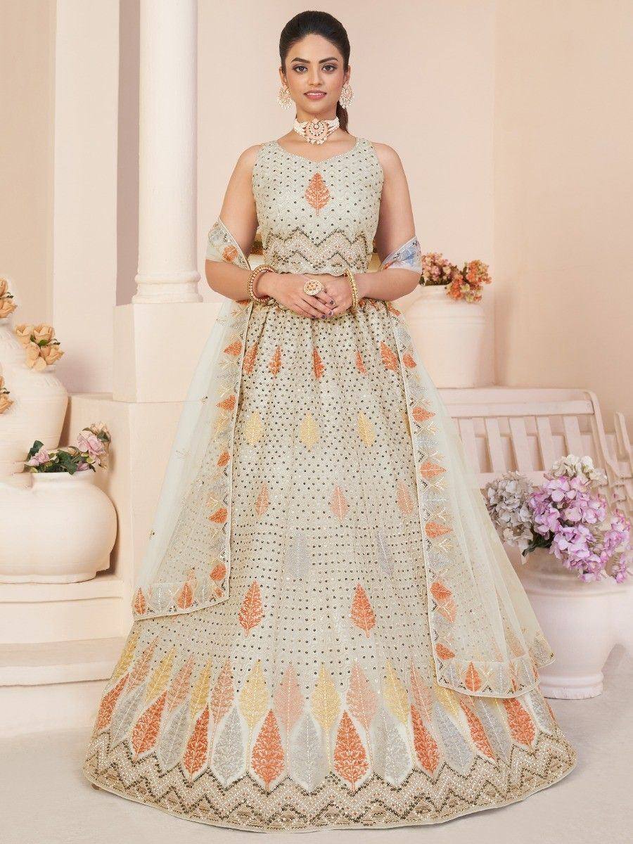 Elegant cream lehenga choli with orange leaf embroidery, perfect for Indian weddings and festive occasions.