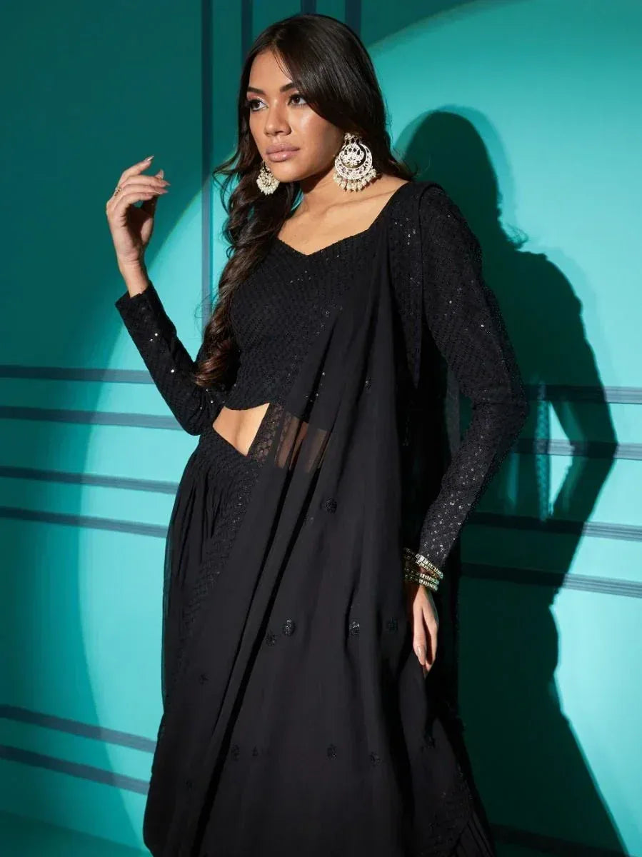 Black embroidered ethnic gown with sheer sleeves and cut-out detail, styled with statement earrings