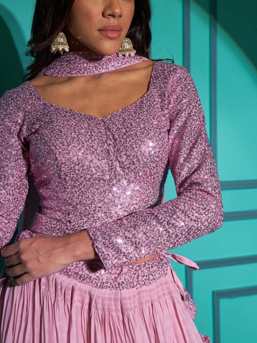 Pink sequin ethnic top with cutout neck, paired with pleated skirt, styled with jhumka earrings