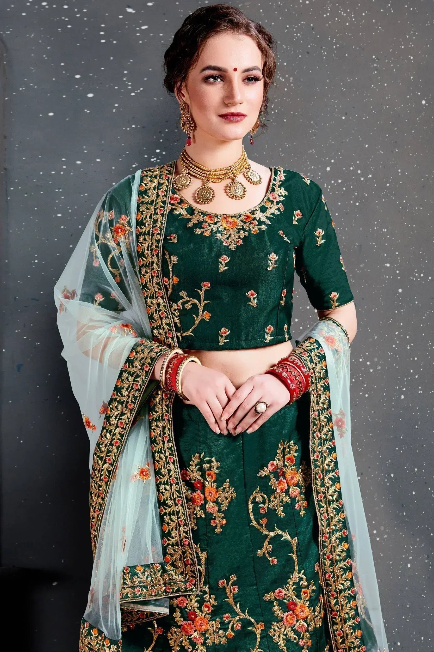 Emerald green embroidered lehenga choli with floral gold detailing and sheer dupatta, perfect for Indian ethnic wear.