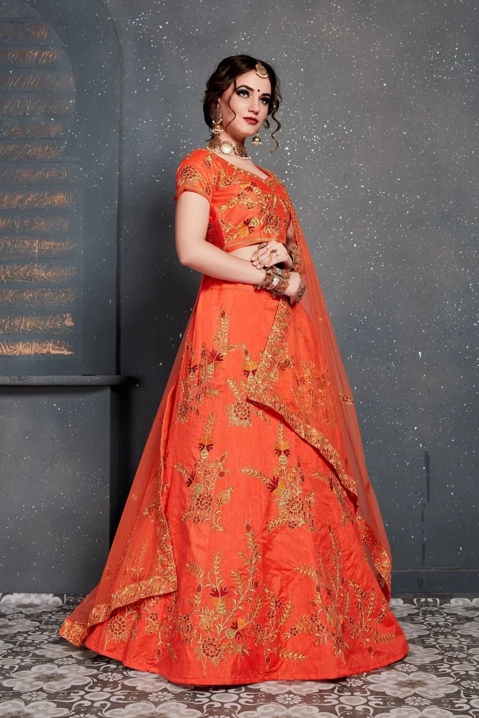 Orange embroidered lehenga choli with gold floral work, perfect for Indian weddings and festive occasions