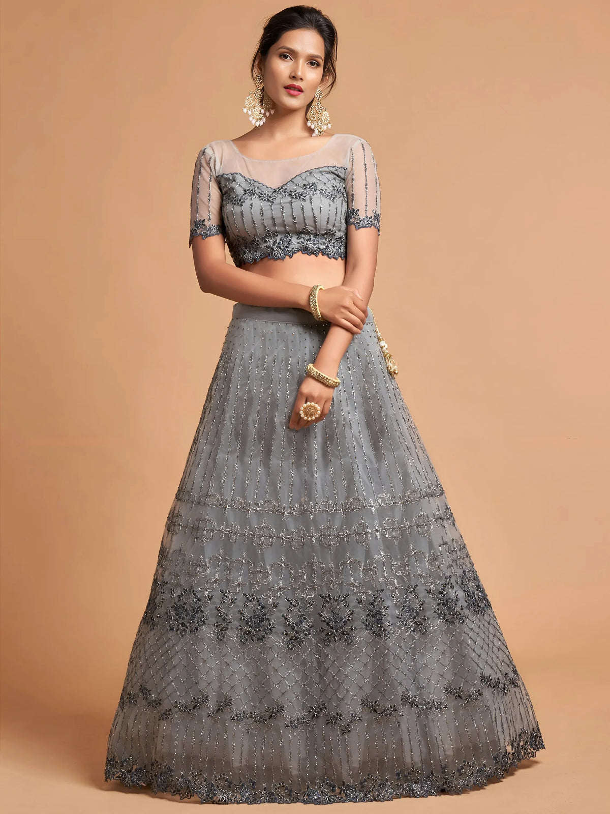 Woman wearing a grey designer lehenga choli with intricate silver embroidery