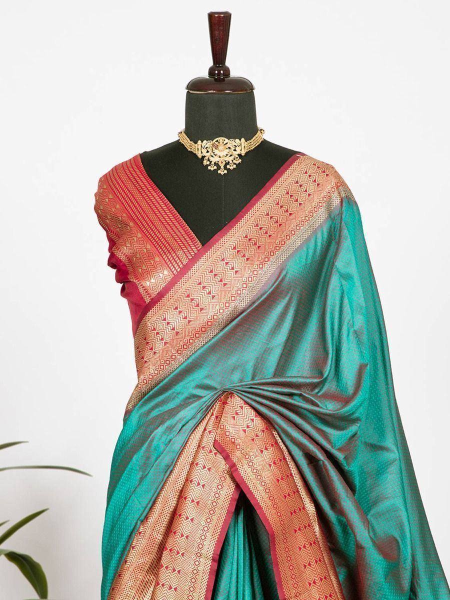Teal and red ethnic saree with gold geometric border, styled on mannequin with traditional necklace