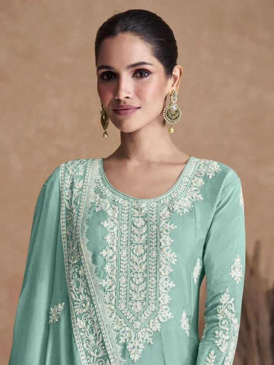 Mint green embroidered ethnic kurti with white floral detailing and gold jhumka earrings