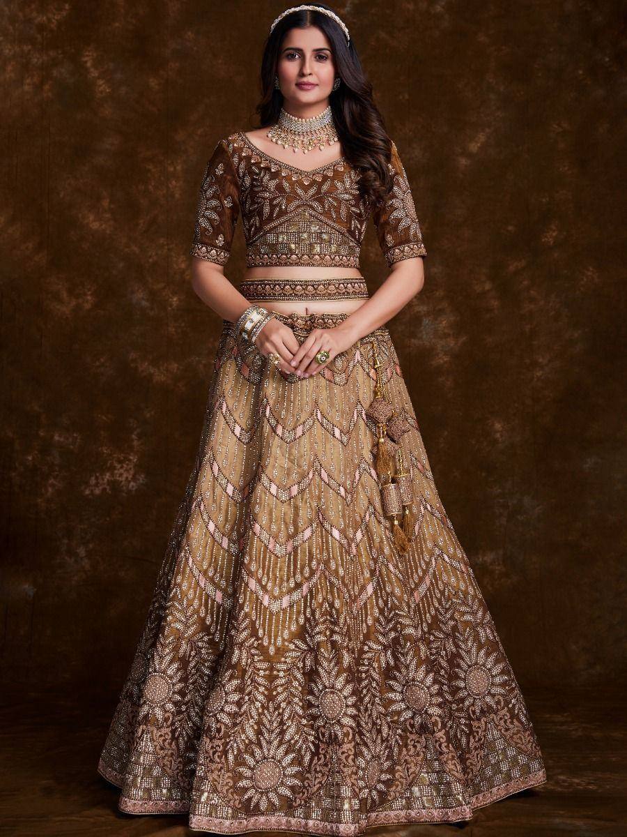 Elegant brown and gold embroidered lehenga choli with intricate mirror work and tassels, perfect for weddings.