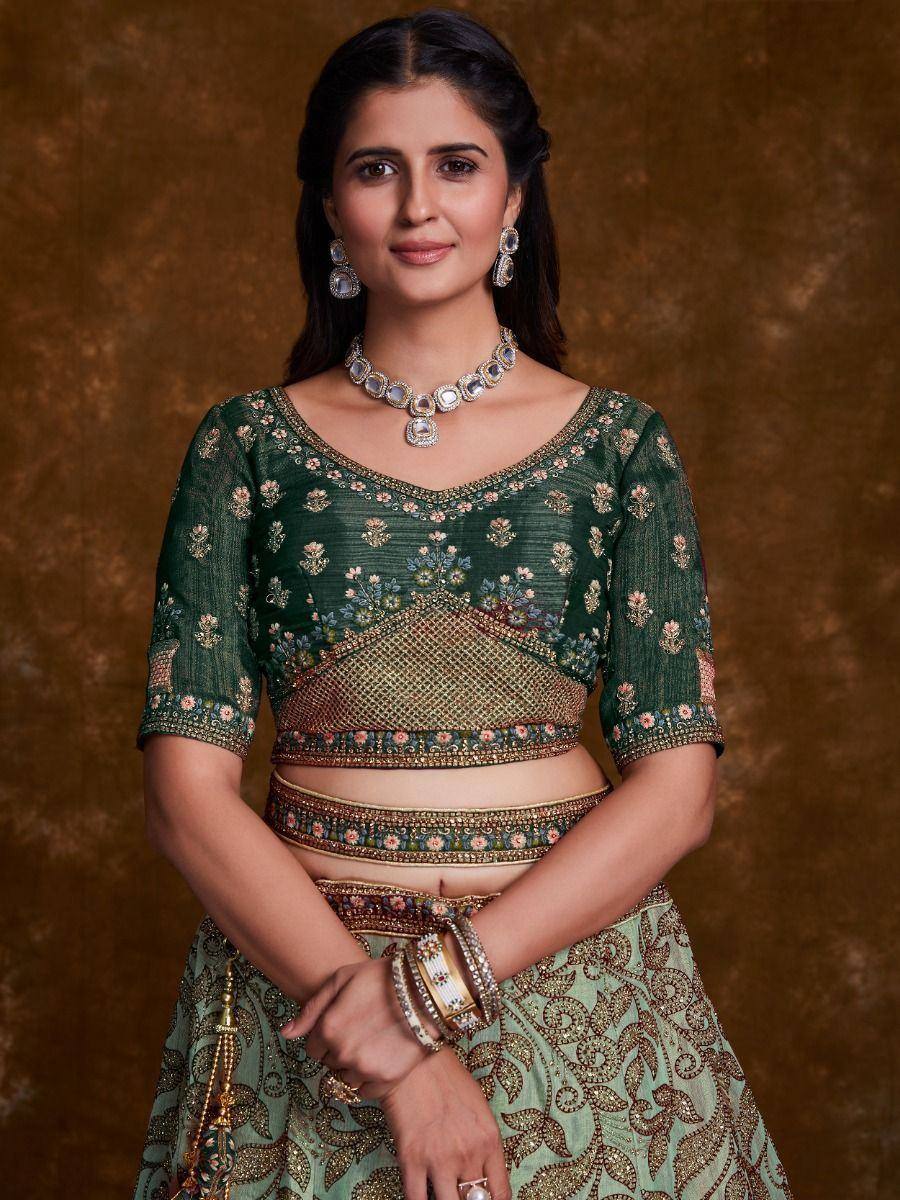 Green embroidered lehenga choli with floral motifs and gold detailing, perfect for Indian ethnic wear occasions.