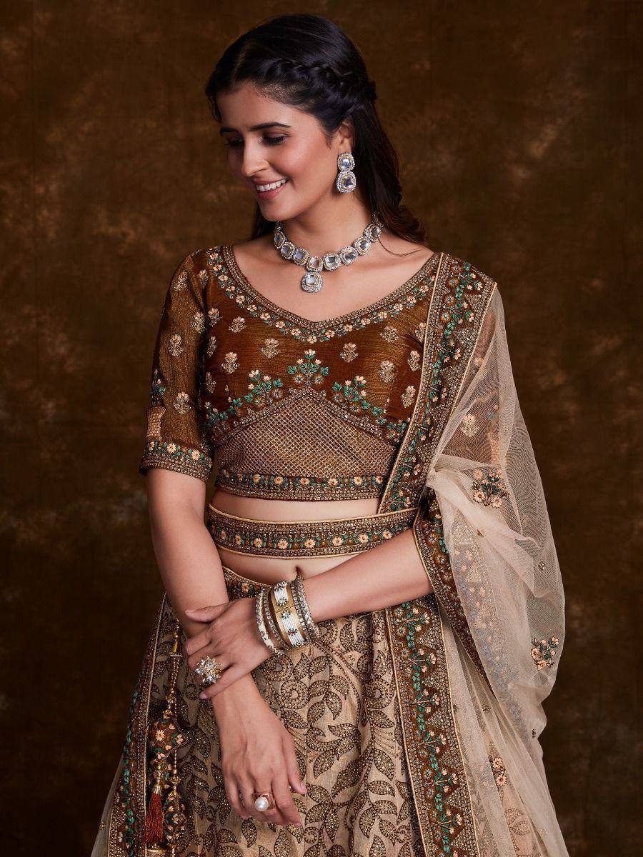 Elegant brown embroidered lehenga choli with floral motifs, sheer dupatta, and traditional jewelry for Indian ethnic wear.