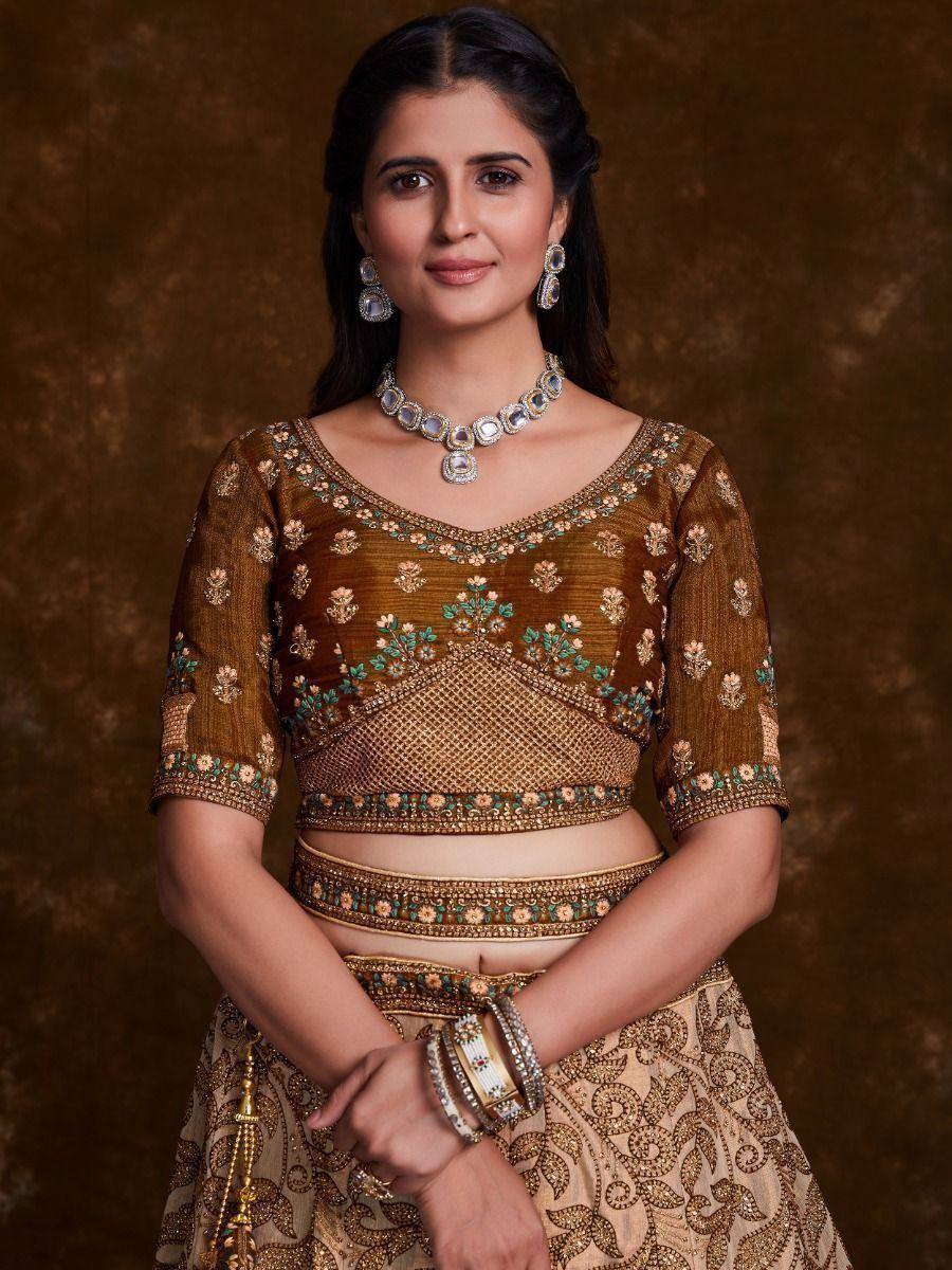 Elegant gold embroidered lehenga choli with floral motifs, perfect for Indian weddings and festive occasions.