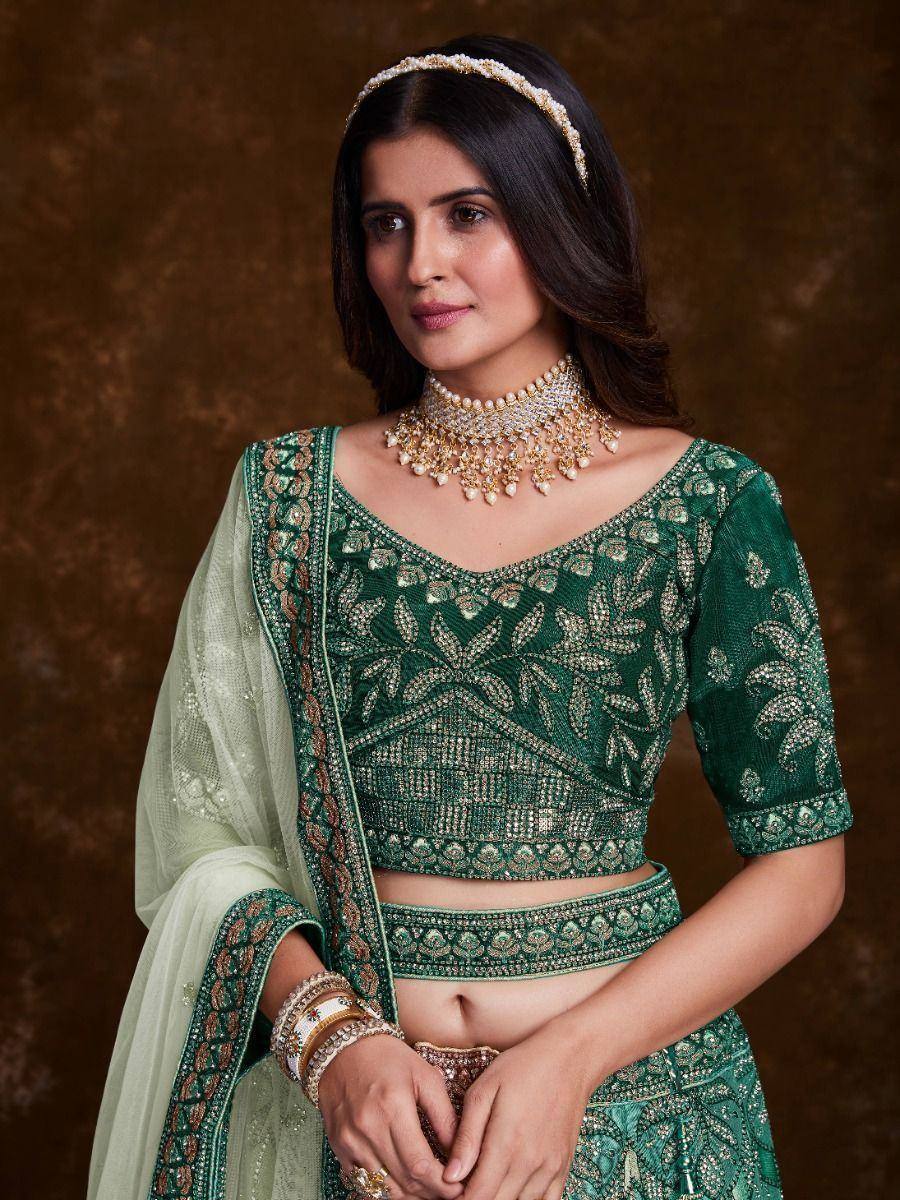 Emerald green designer lehenga choli with intricate embroidery and pearl jewelry for Indian ethnic wear