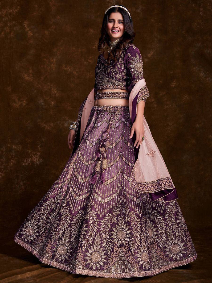 Purple designer lehenga choli with gold embroidery and floral patterns, perfect for Indian weddings and festive occasions.