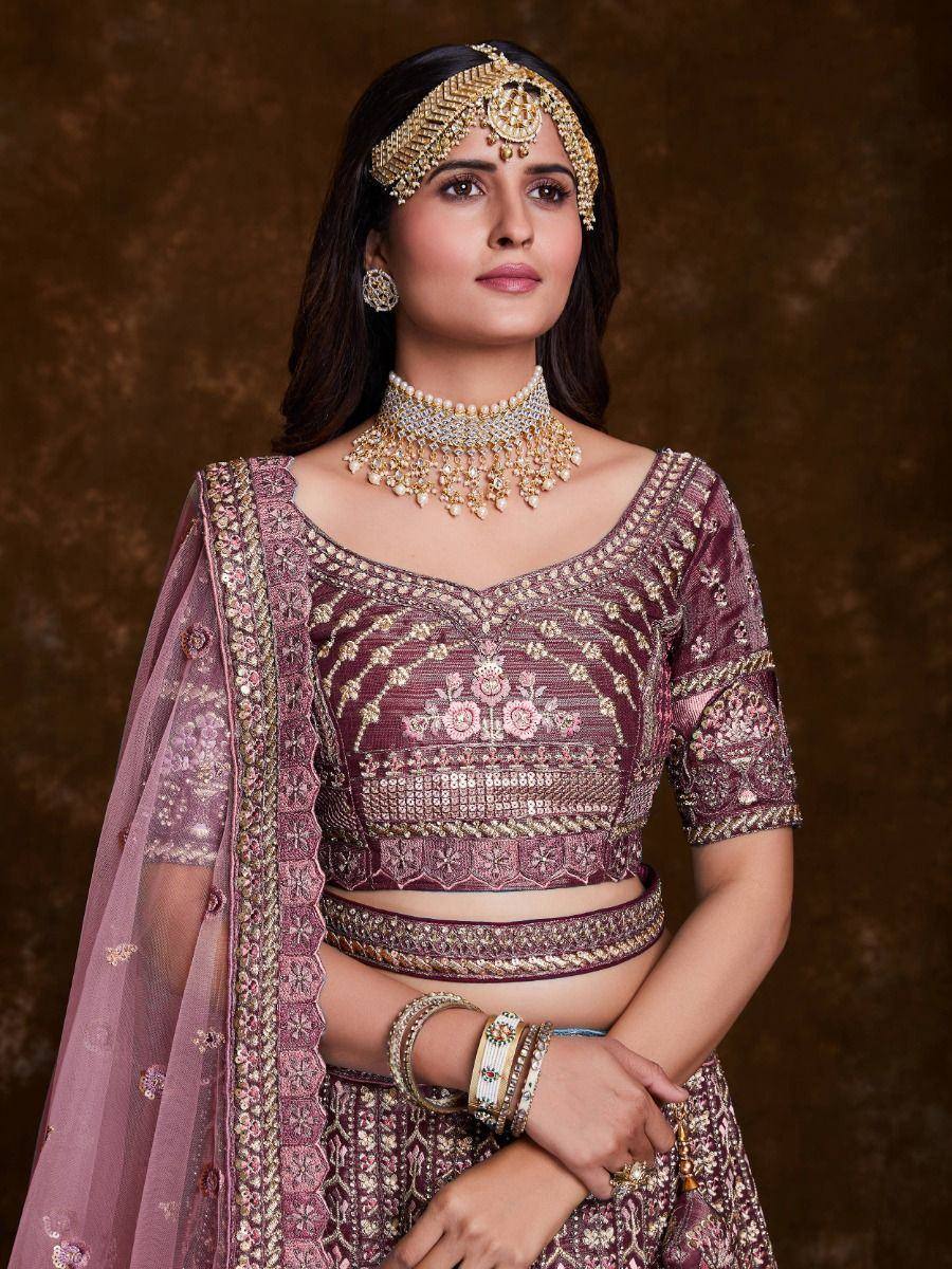 Maroon embroidered lehenga choli with gold jewelry and dupatta, perfect for Indian weddings and festivals
