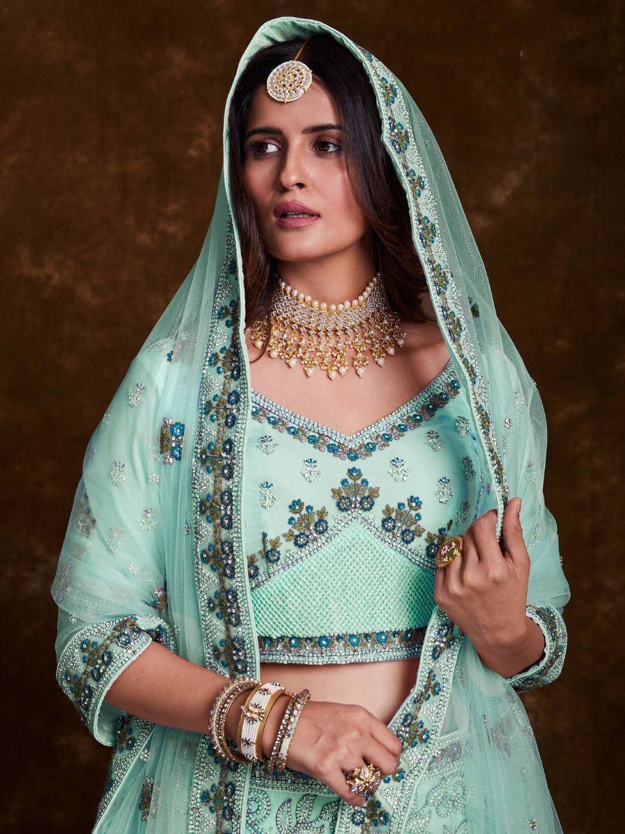 Mint green designer lehenga choli with floral embroidery, dupatta, and traditional jewelry for Indian ethnic wear