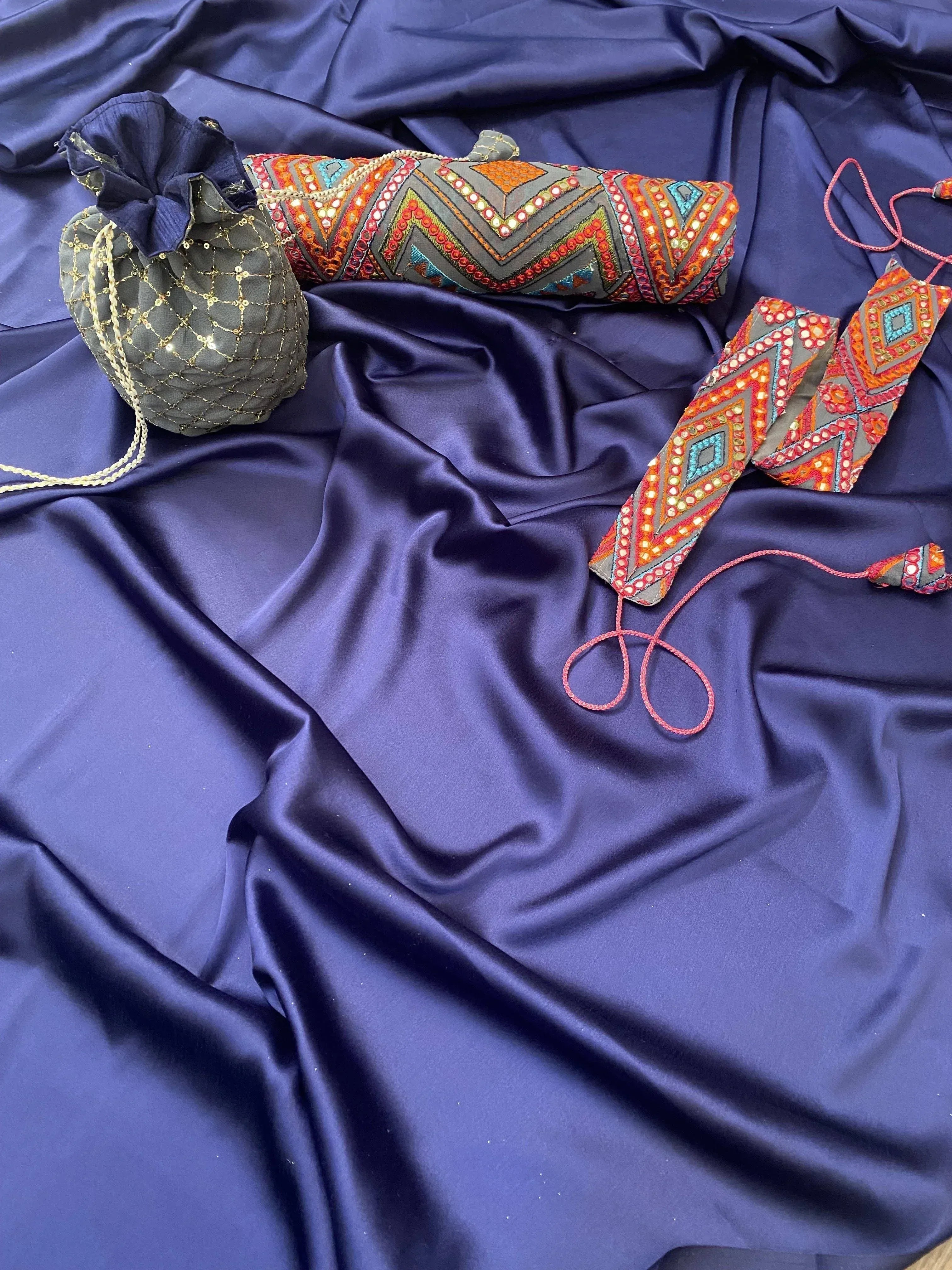 Ethnic Indian clutch bags with mirror work and embroidery on navy satin, perfect for lehenga or saree outfits.