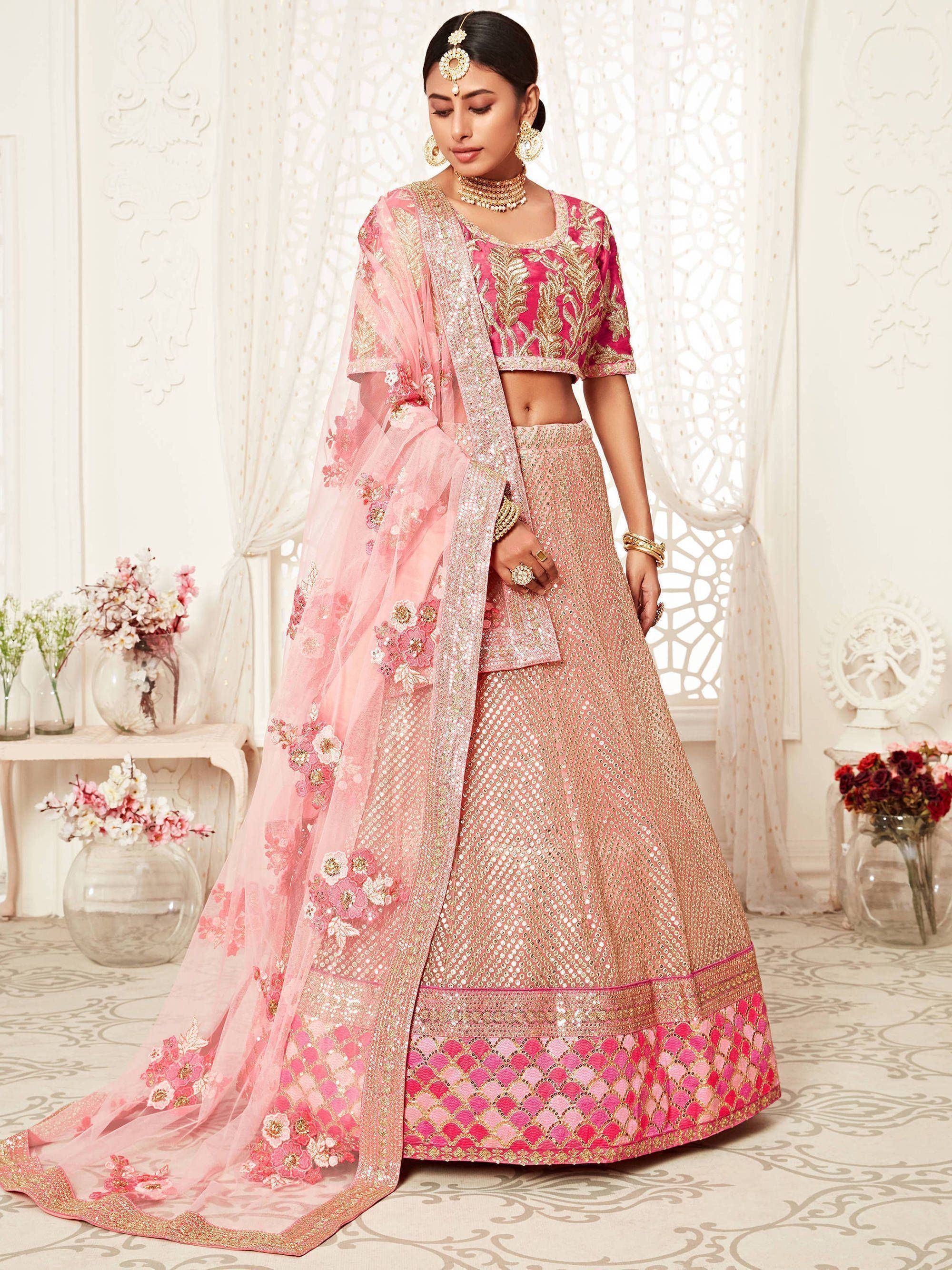 Pink designer lehenga choli with gold embroidery and floral dupatta, perfect for Indian weddings and festive occasions.