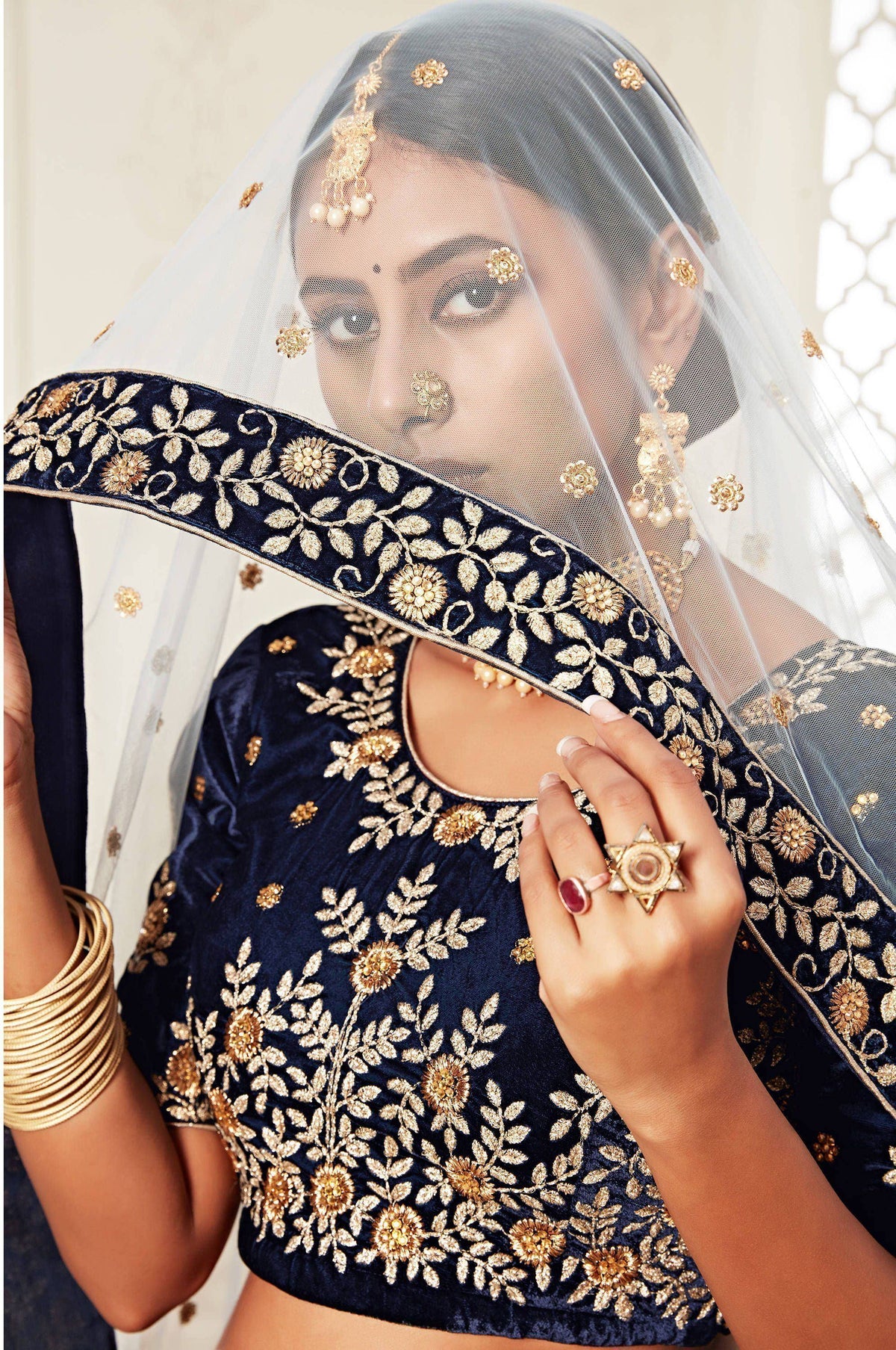 Navy blue velvet lehenga choli with gold floral embroidery and sheer dupatta for Indian weddings