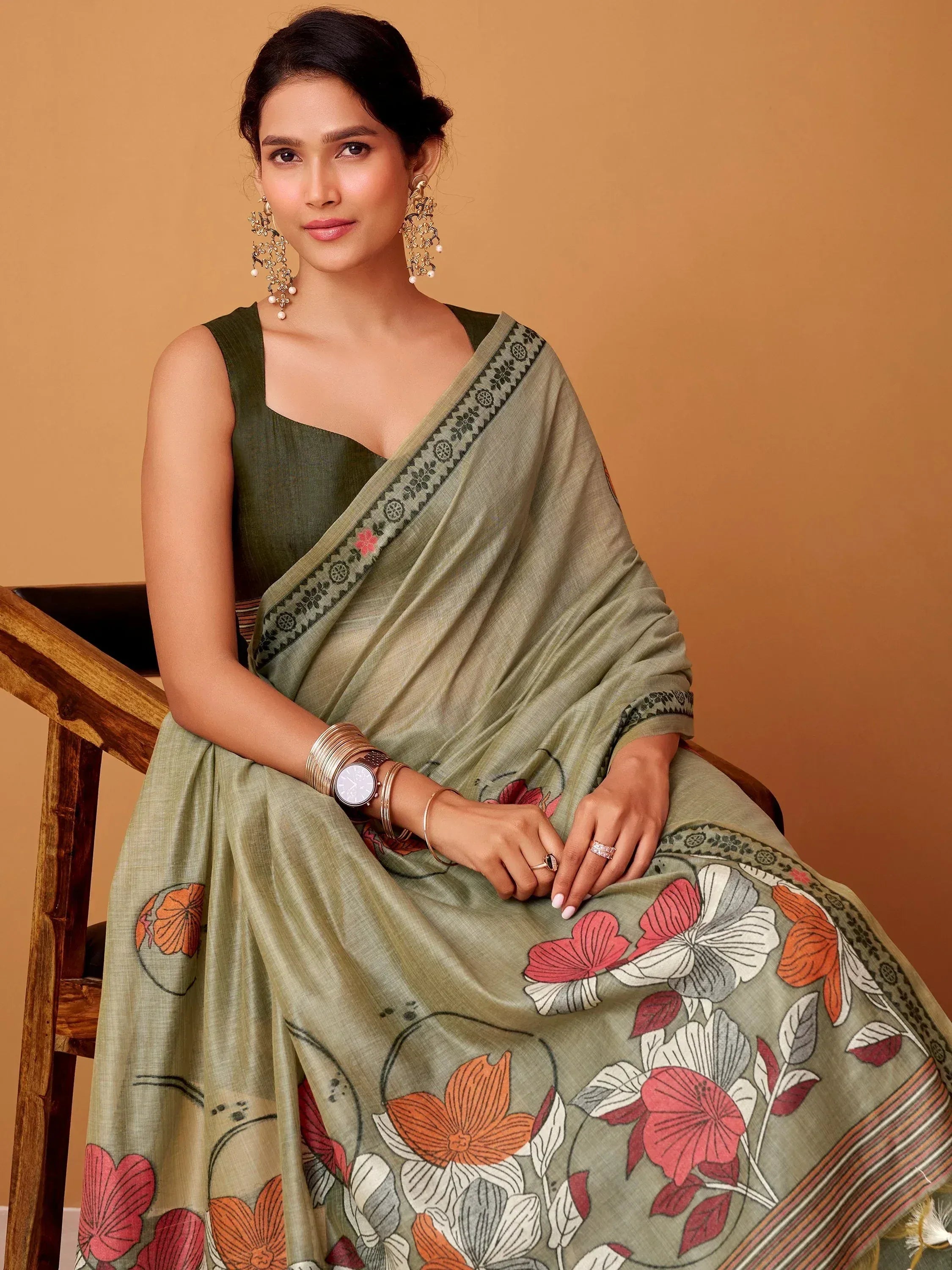 Olive green floral print saree with designer border, paired with sleeveless blouse, perfect for ethnic occasions