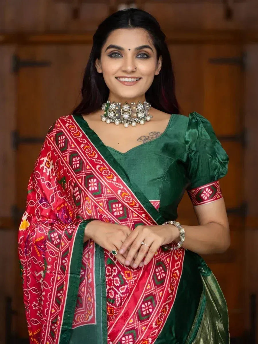 Woman in green velvet blouse with red printed saree, traditional Indian ethnic wear