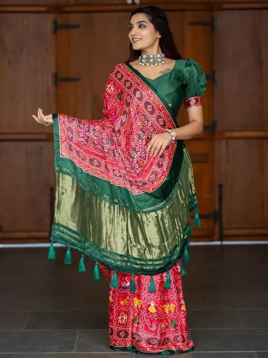 Woman in vibrant red and green ethnic saree with floral print and tassels, perfect for Indian occasions