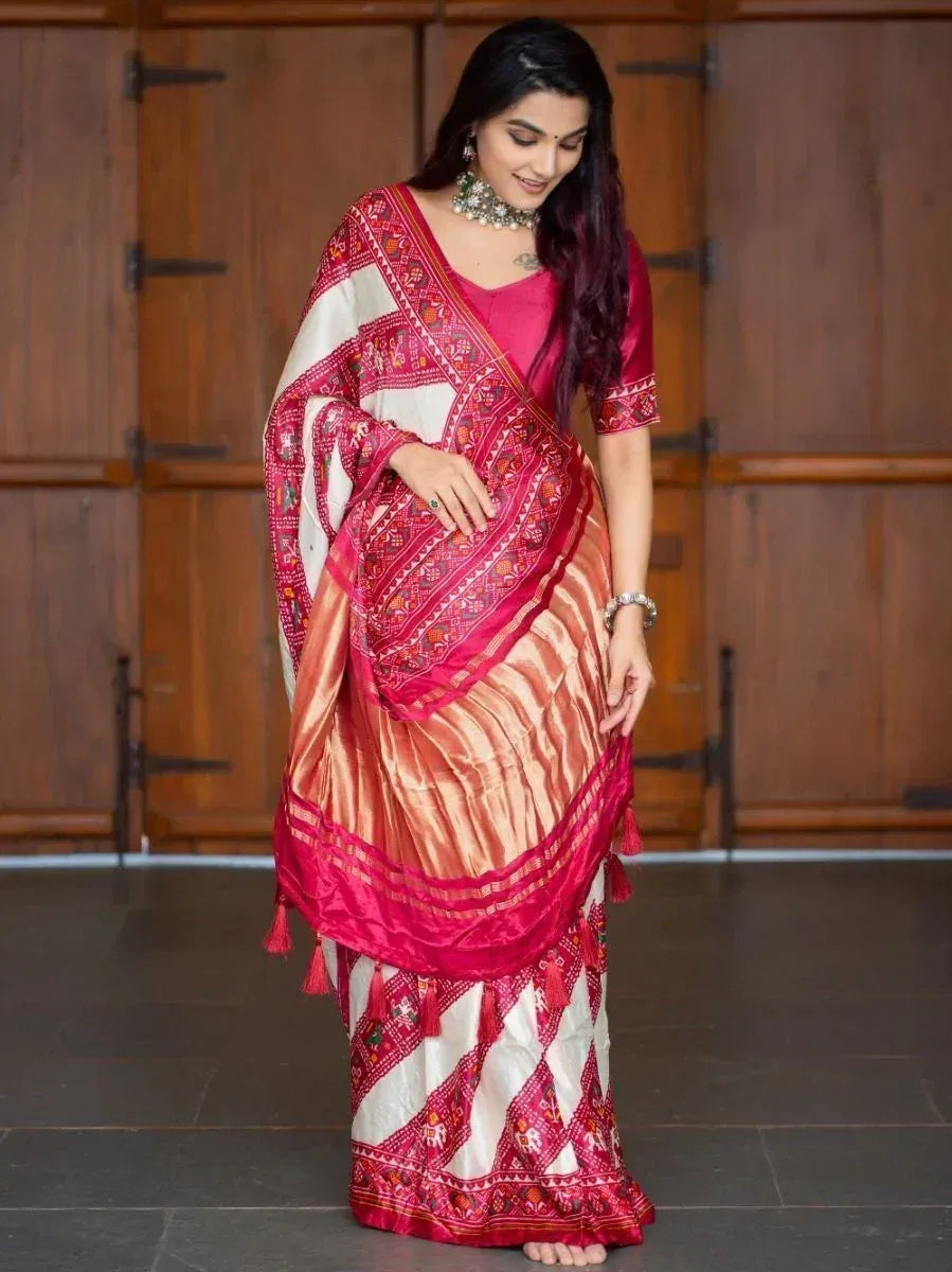 Woman in vibrant pink and white embroidered saree with tassels, styled with traditional jewelry for ethnic occasions