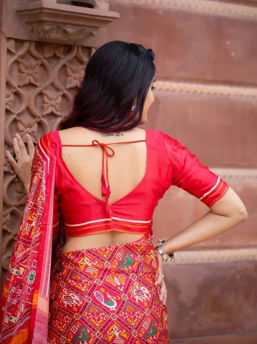 Red backless blouse with tie detail paired with printed ethnic saree, perfect for Indian occasions