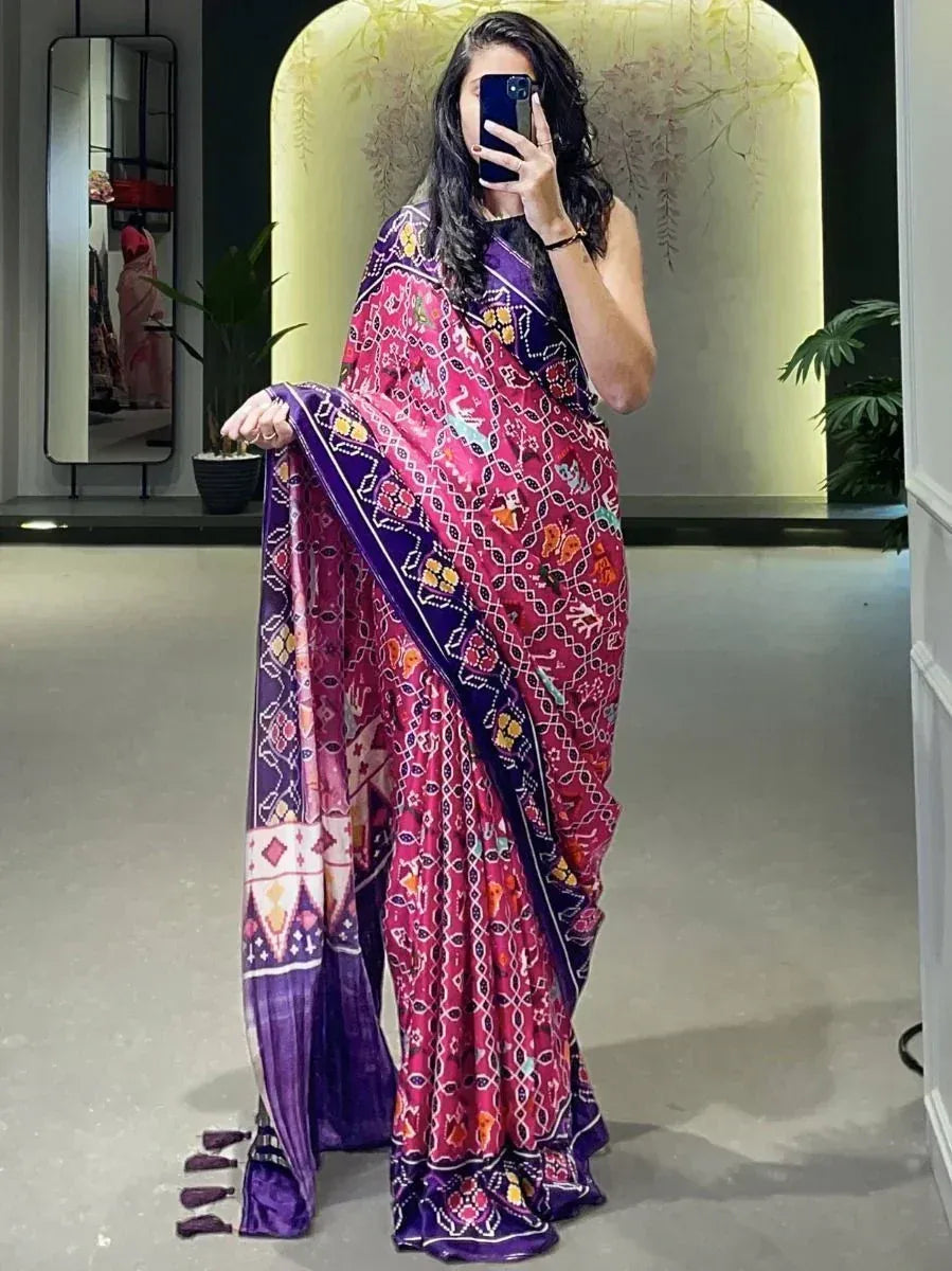 Woman in vibrant pink and purple printed saree with ethnic motifs, perfect for festive occasions