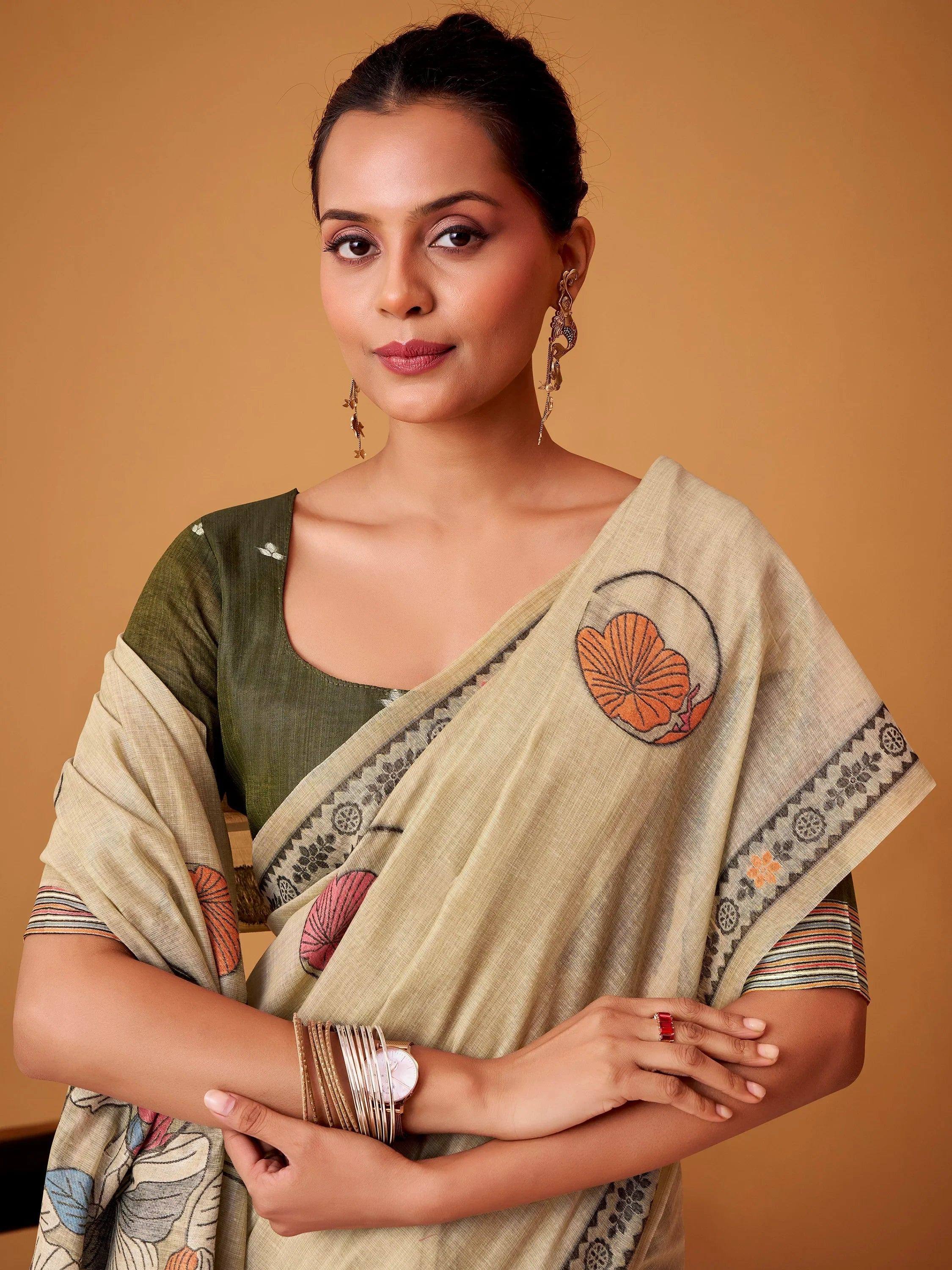 Woman in beige printed saree with olive green blouse, floral motifs, and ethnic jewelry
