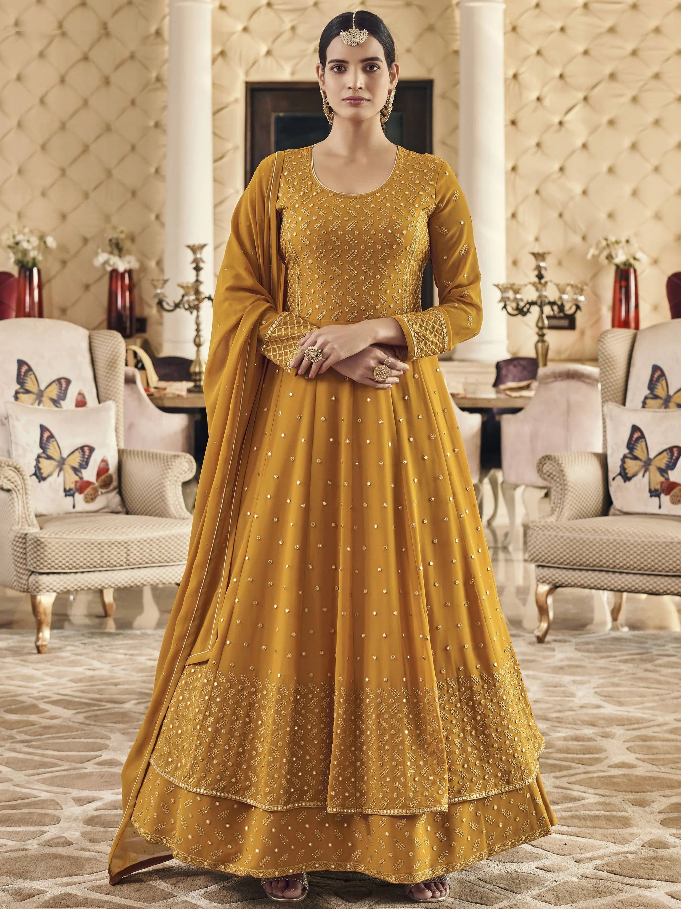 Woman in mustard yellow embroidered ethnic gown with dupatta, traditional Indian wear