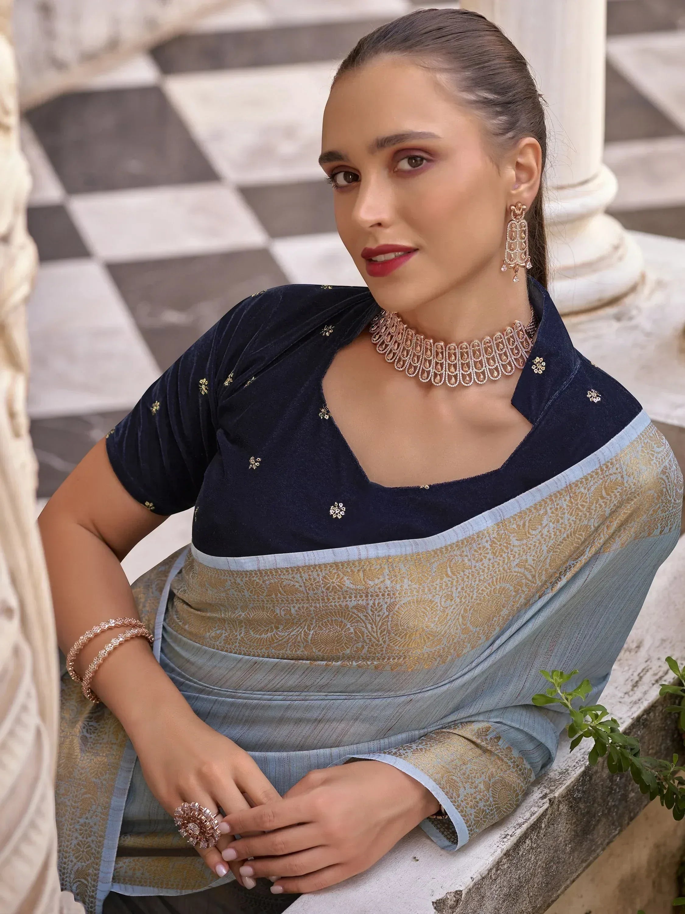Woman in elegant blue and gold saree with velvet blouse, perfect for Indian ethnic occasions.