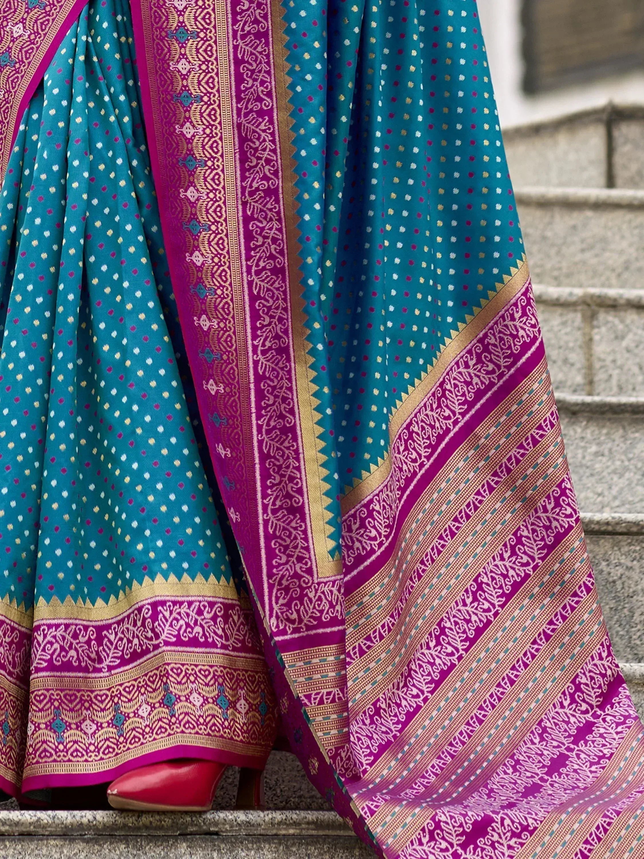 Teal and magenta ethnic saree with intricate gold border and polka dot pattern, perfect for Indian occasions.