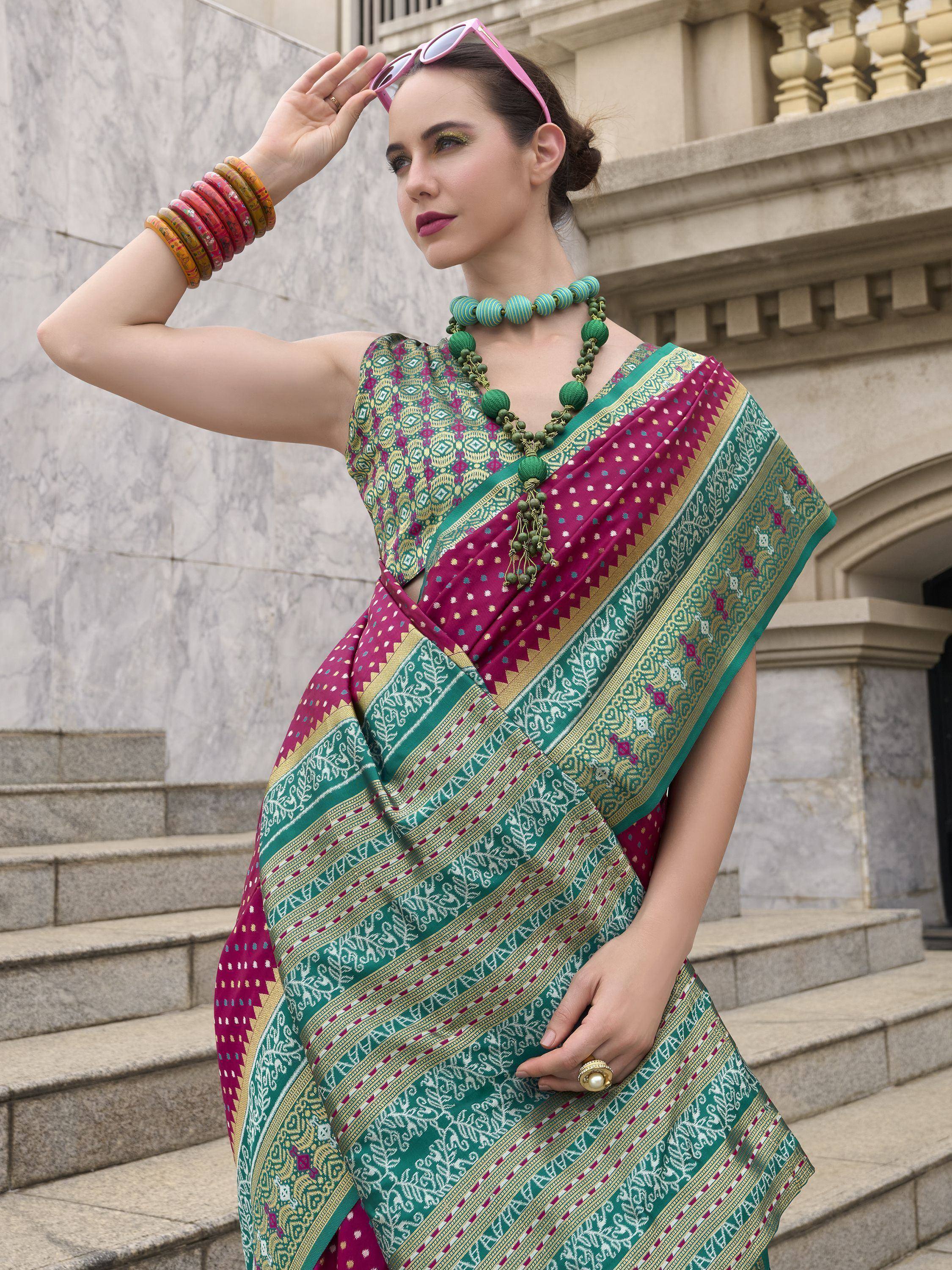 Woman in vibrant green and magenta ethnic saree with intricate patterns, styled with bangles and necklace