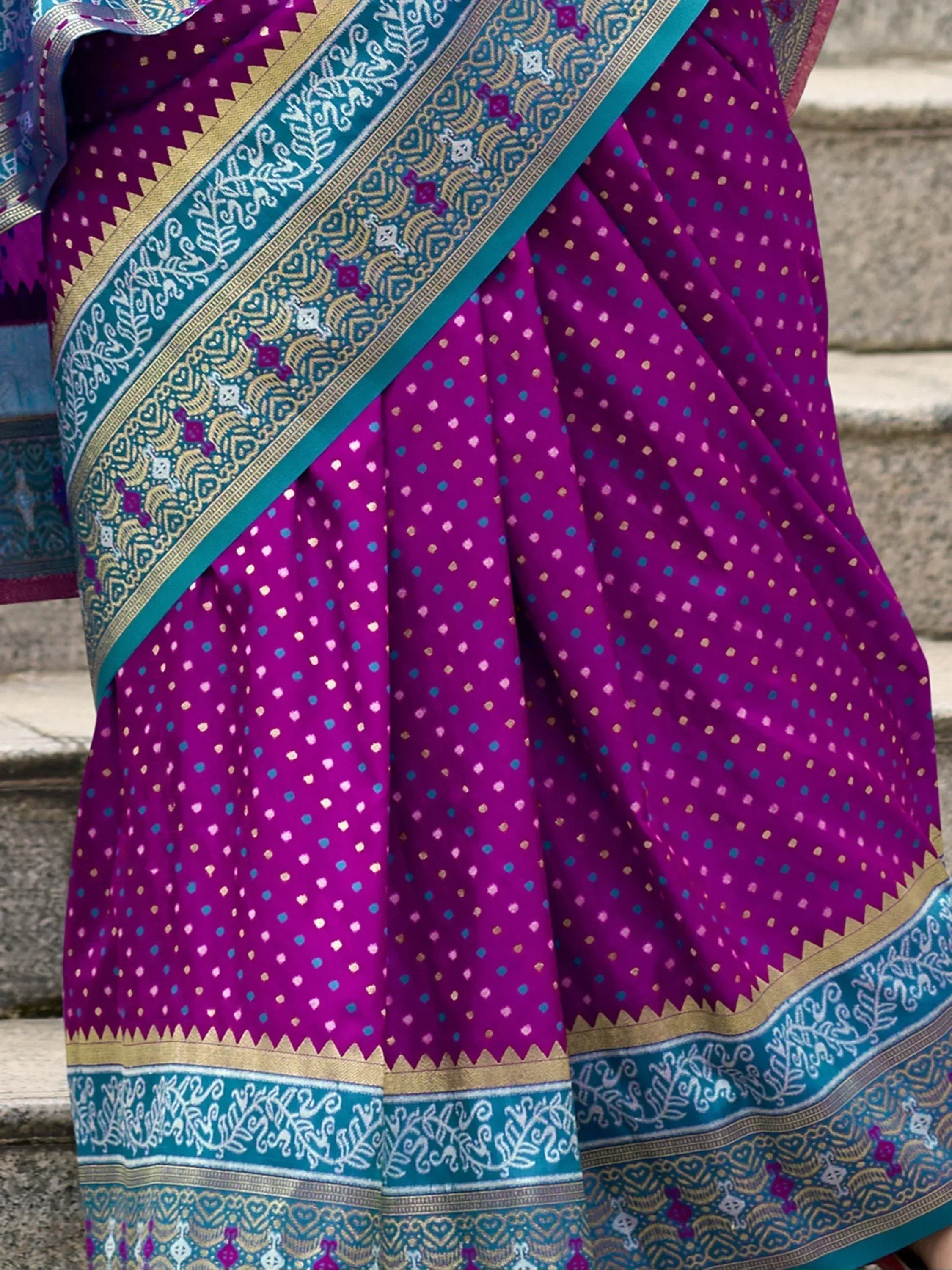 Purple ethnic saree with teal border, gold motifs, and intricate woven patterns for traditional Indian wear