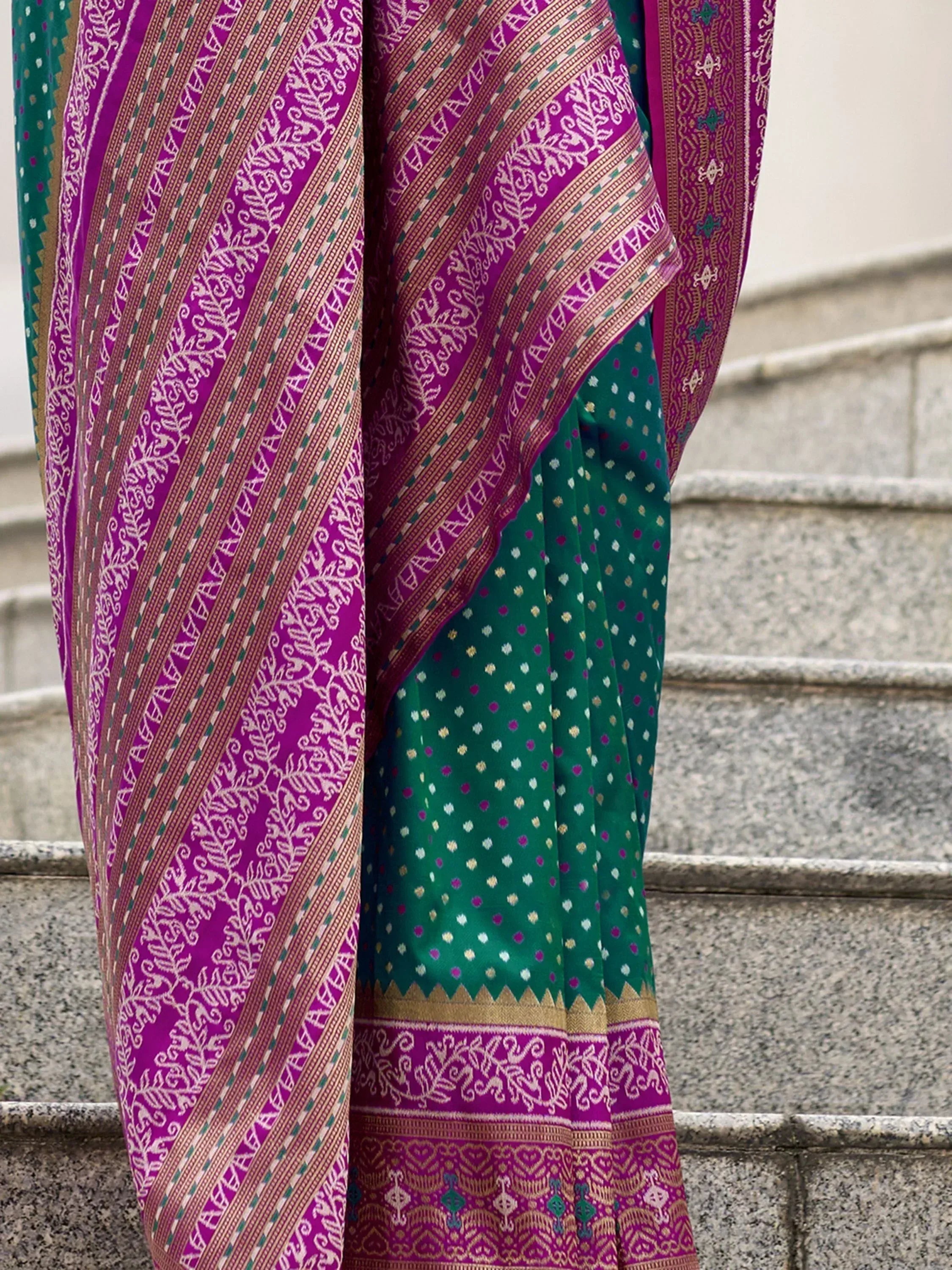 Emerald green saree with magenta border, intricate gold zari work, and traditional Indian ethnic print