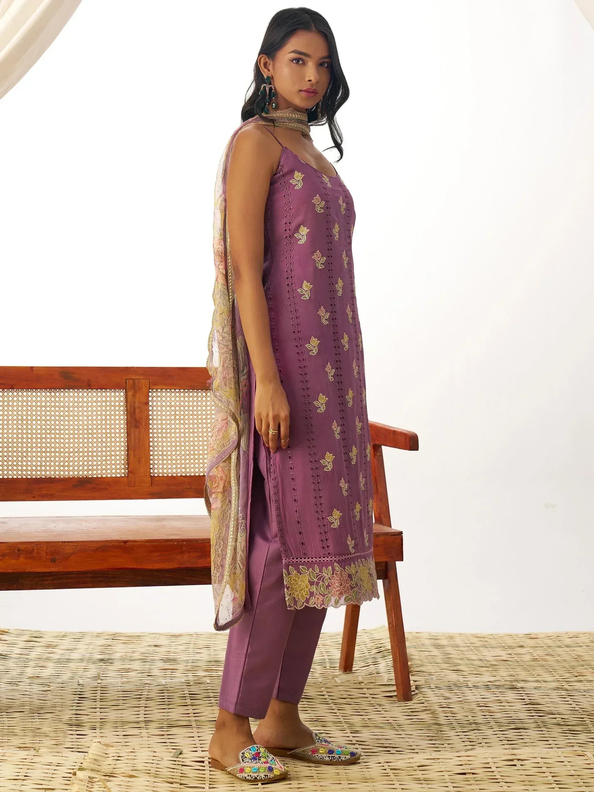Purple embroidered ethnic kurti with matching pants and floral dupatta, styled with colorful juttis for Indian wear.