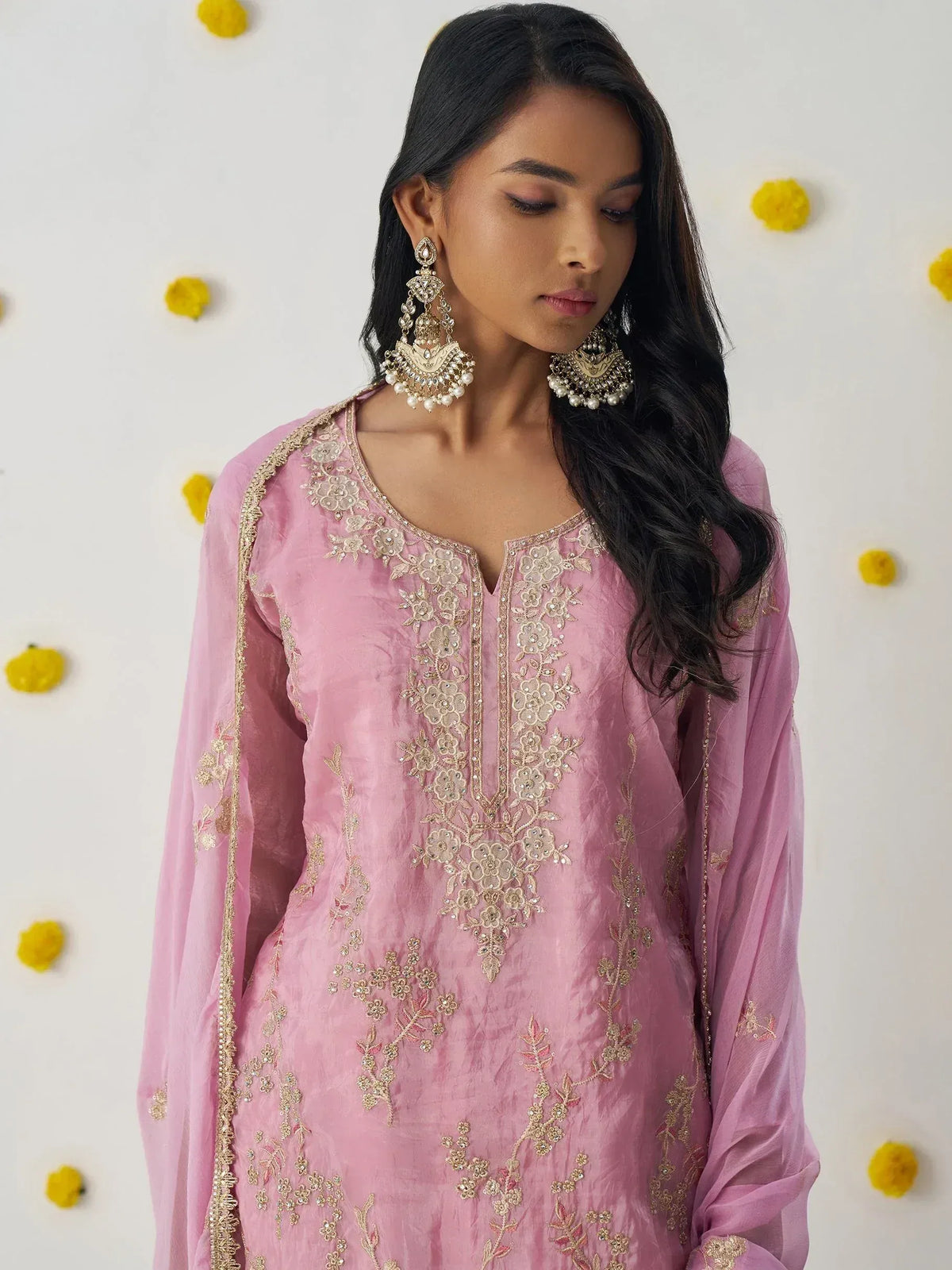Pink embroidered ethnic kurta with gold floral detailing and statement earrings, perfect for Indian occasions.