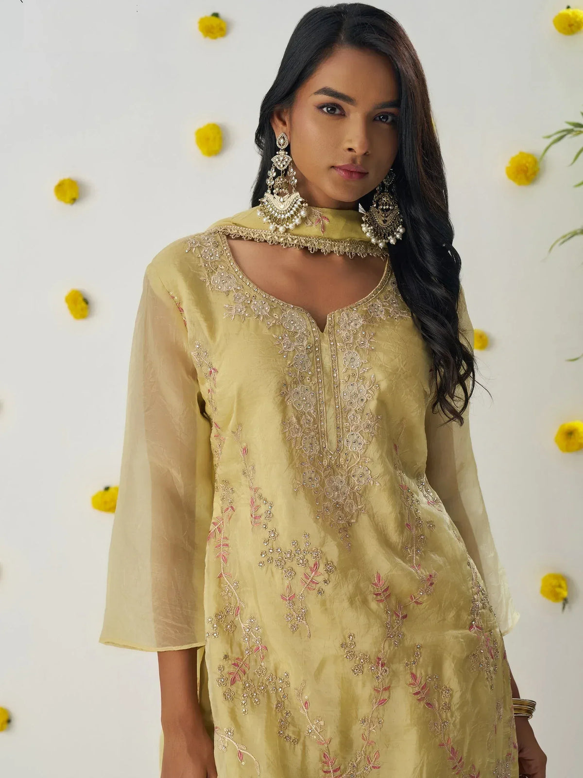 Yellow embroidered ethnic kurta with floral detailing and statement earrings, perfect for Indian festive wear.