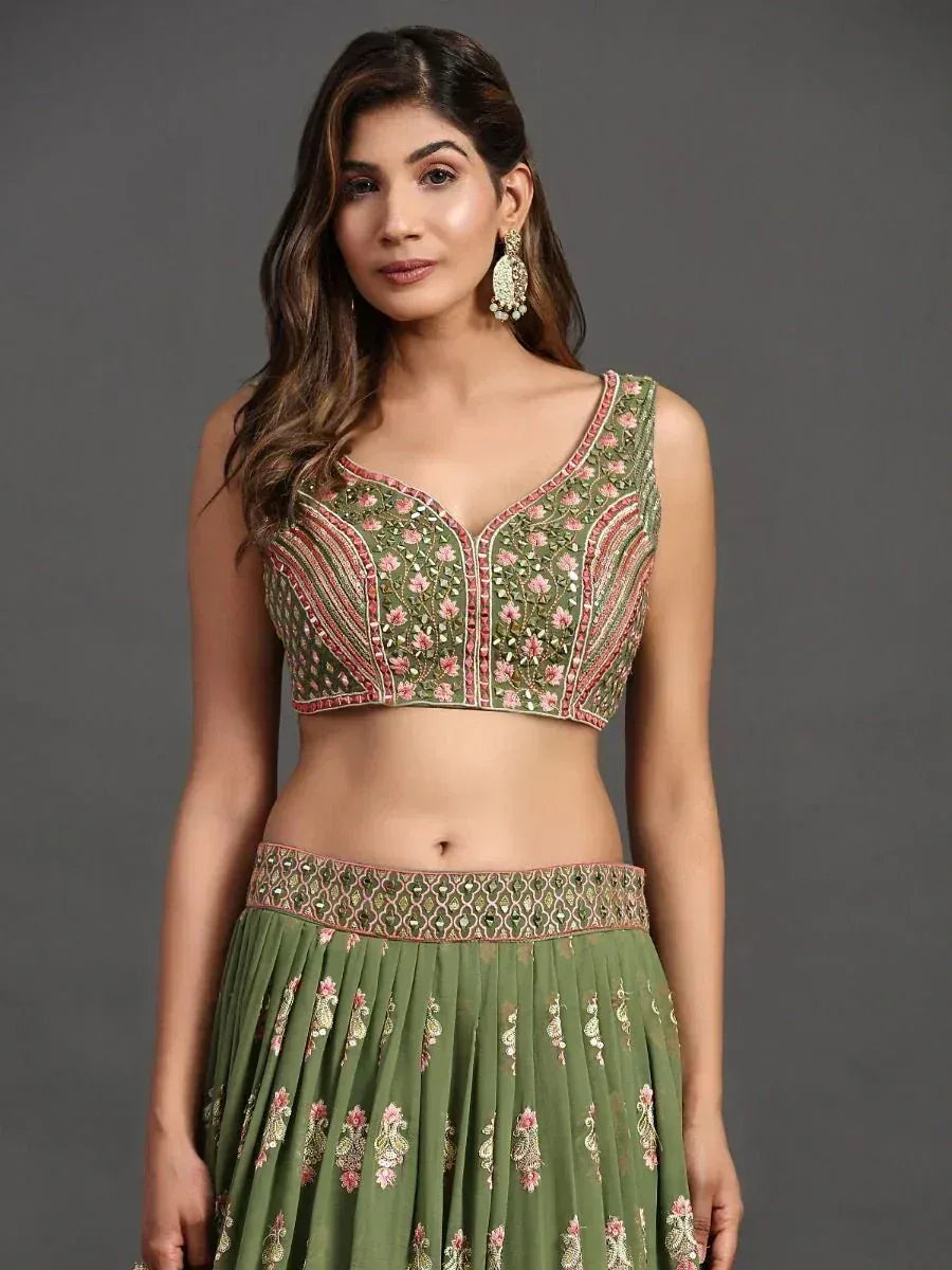 Green embroidered lehenga choli with floral motifs and mirror work, perfect for Indian ethnic occasions