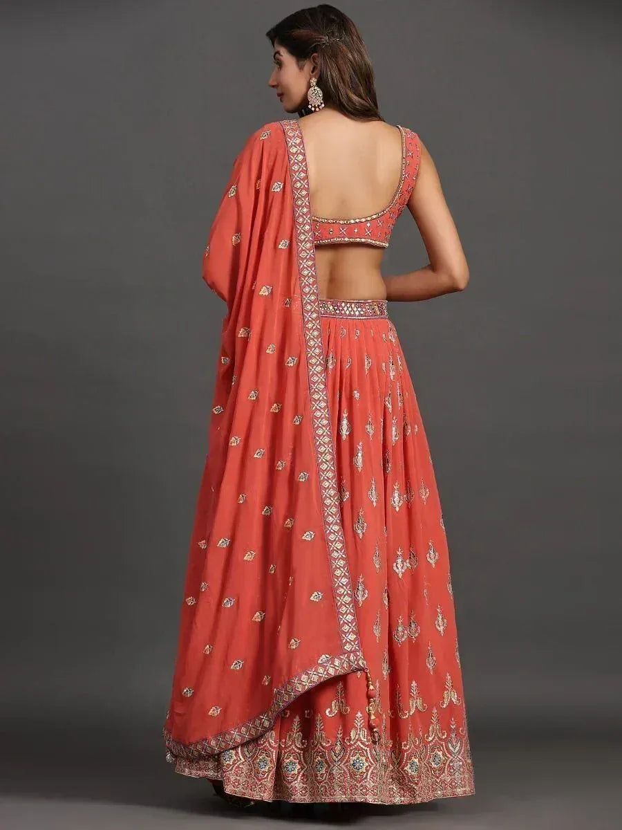Coral designer lehenga choli with intricate gold embroidery and backless blouse, perfect for Indian ethnic wear.