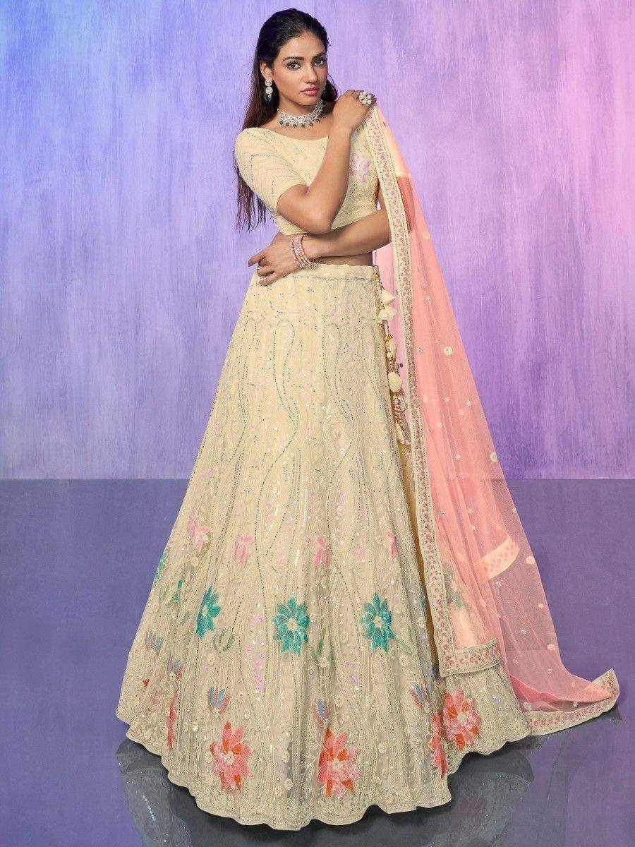Elegant cream lehenga choli with floral embroidery and pink dupatta, perfect for Indian weddings and festive occasions.