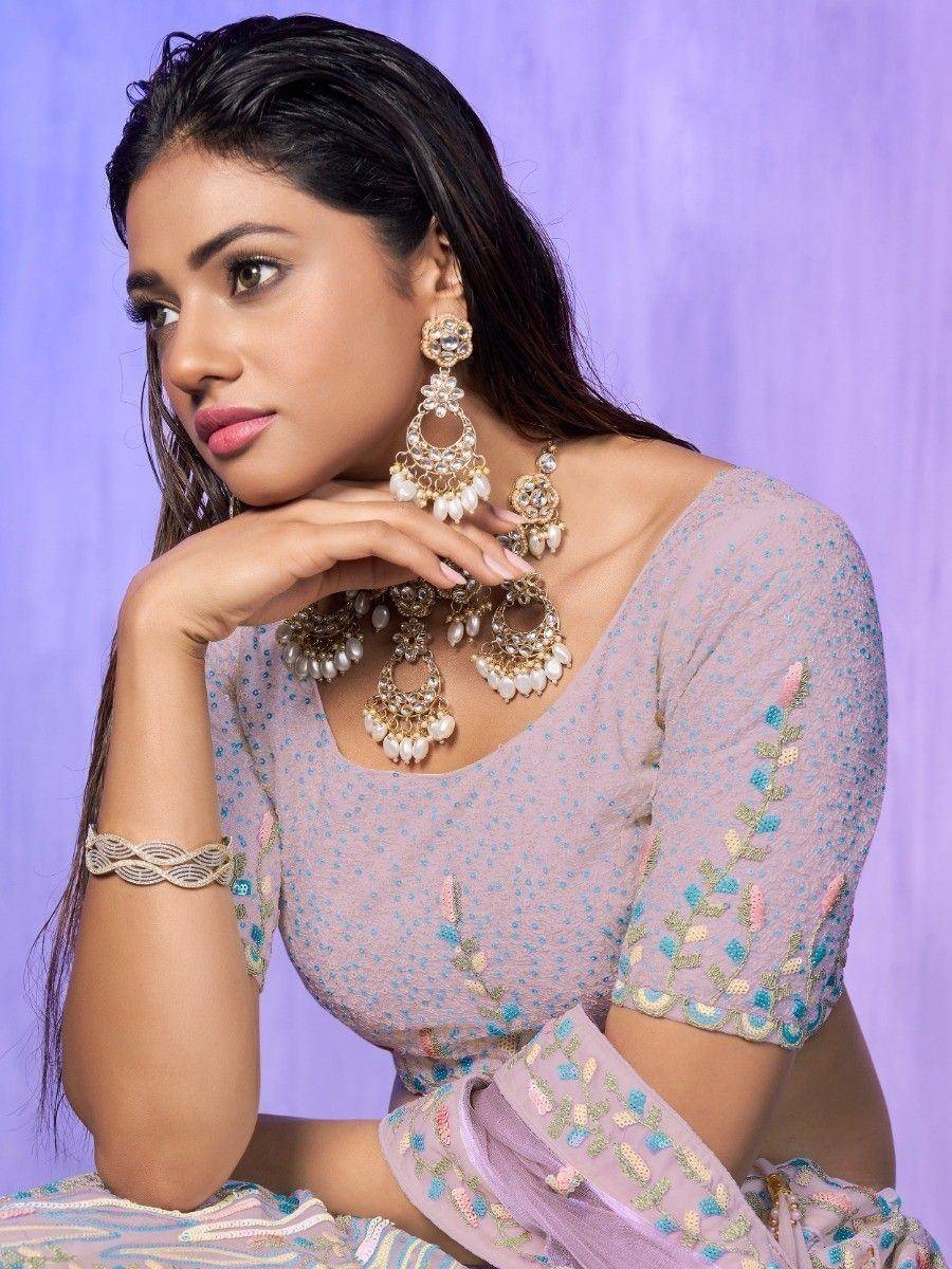Elegant lavender embroidered lehenga choli with pearl jewelry, perfect for Indian ethnic occasions.