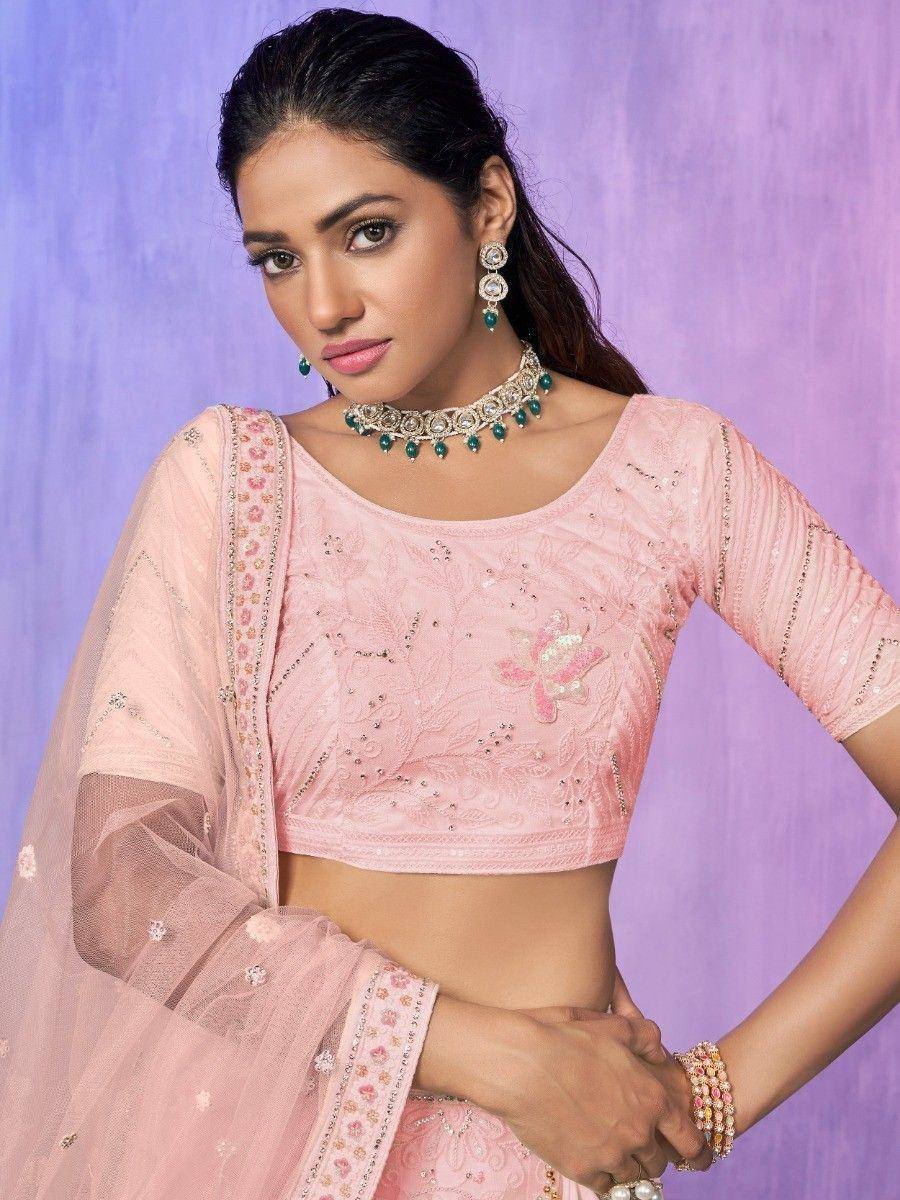Pink embroidered lehenga choli with floral detailing, sheer dupatta, and emerald jewelry for Indian ethnic wear