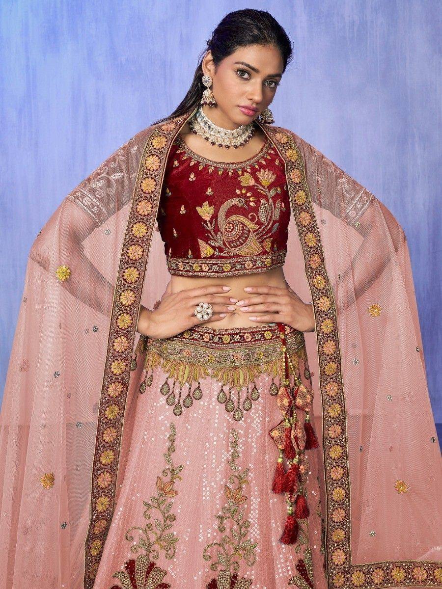 Elegant maroon and pink embroidered lehenga choli with peacock motif, perfect for Indian weddings and festive occasions.