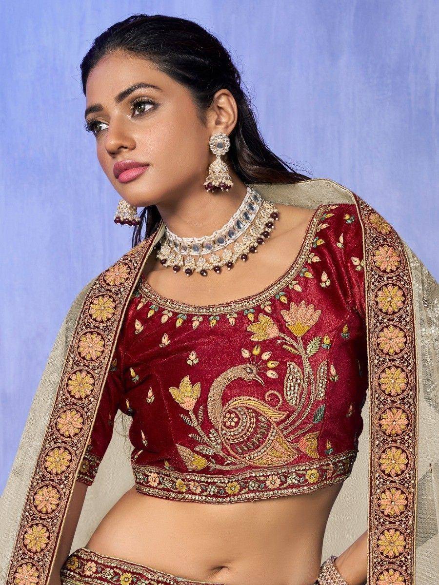 Maroon velvet lehenga choli with peacock embroidery, floral border, and traditional jewelry