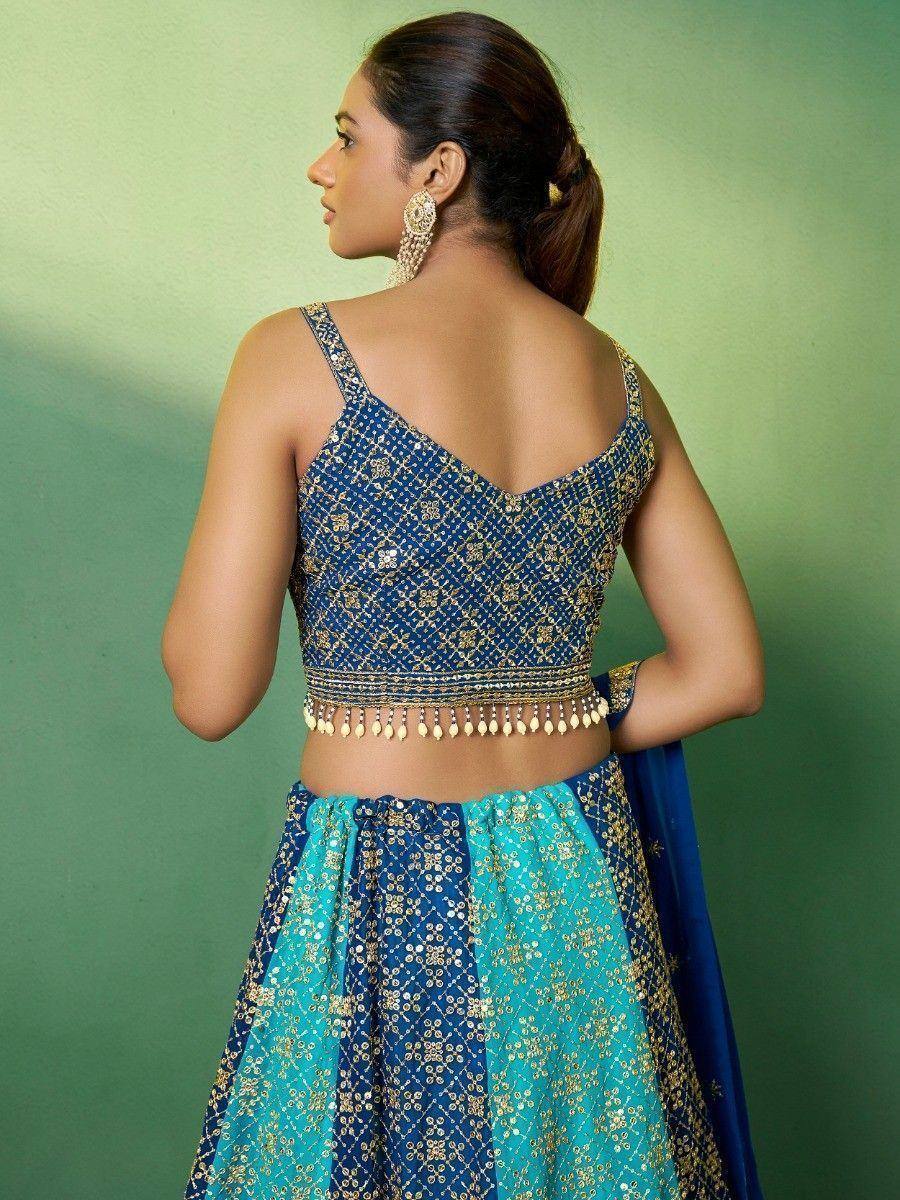 Blue and teal embroidered lehenga choli with gold detailing and backless blouse
