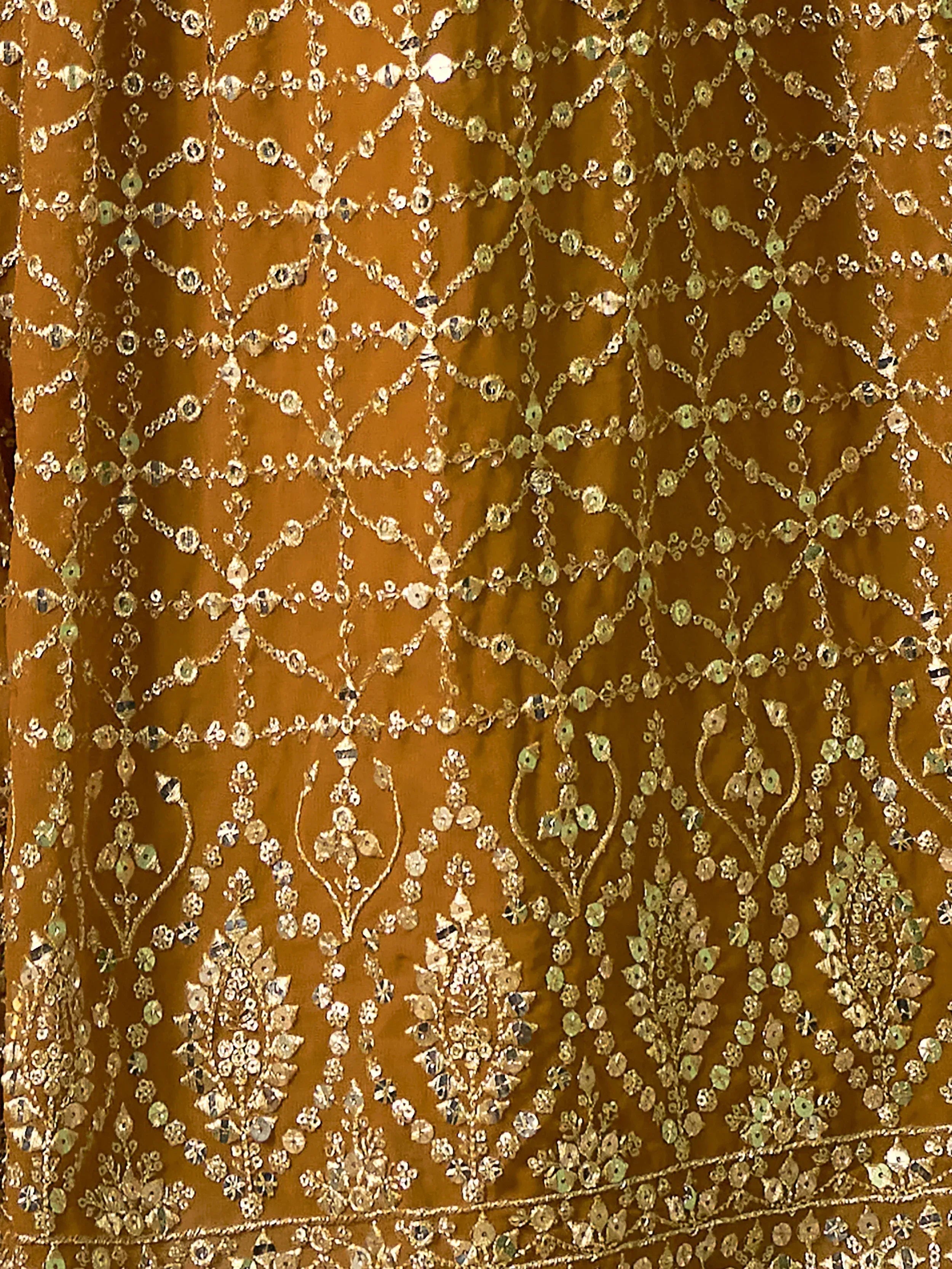 Rich mustard ethnic wear with intricate gold embroidery and mirror work, perfect for festive occasions.