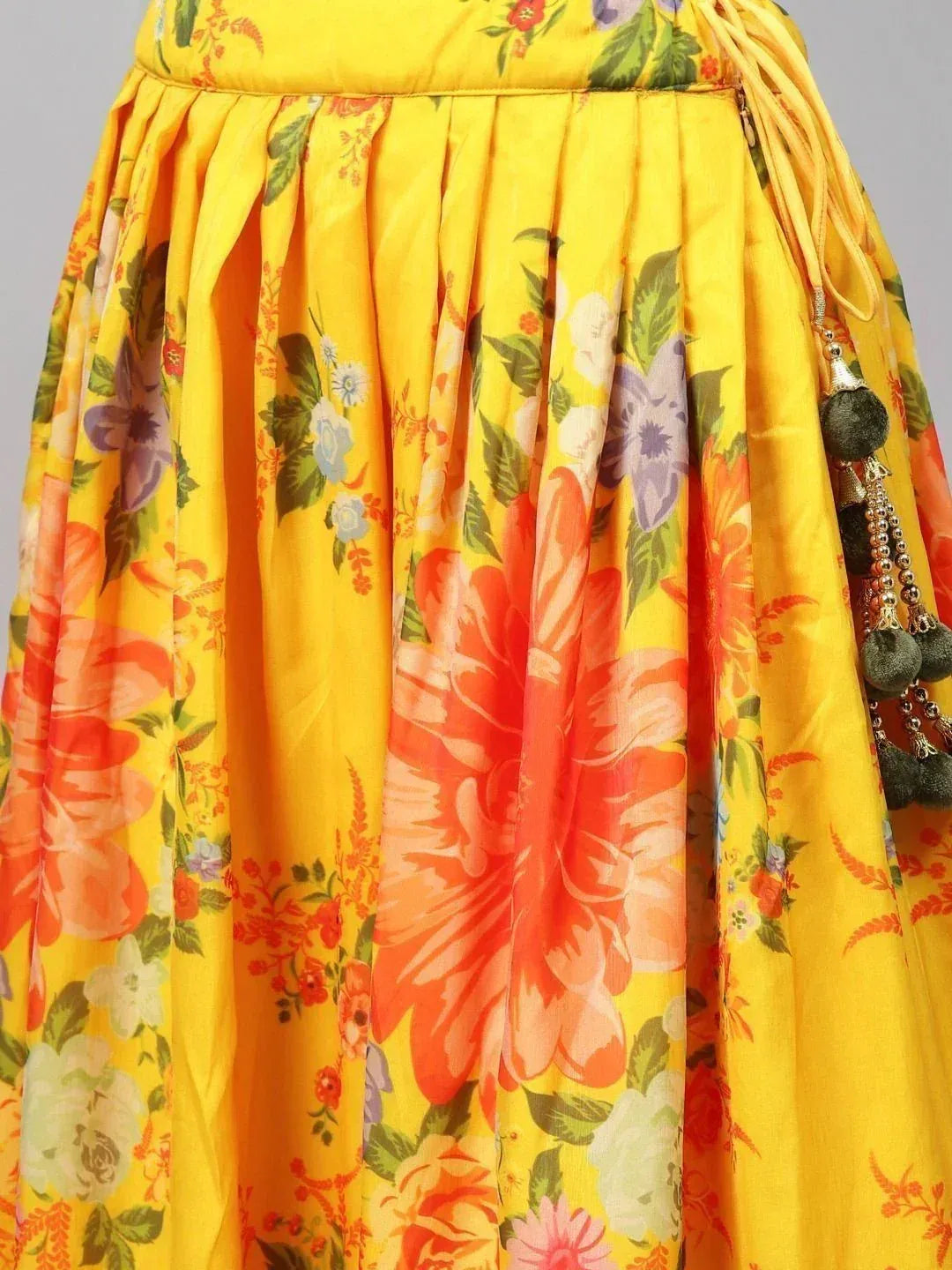 Vibrant yellow floral lehenga skirt with pleats and tassel detailing, perfect for ethnic wear