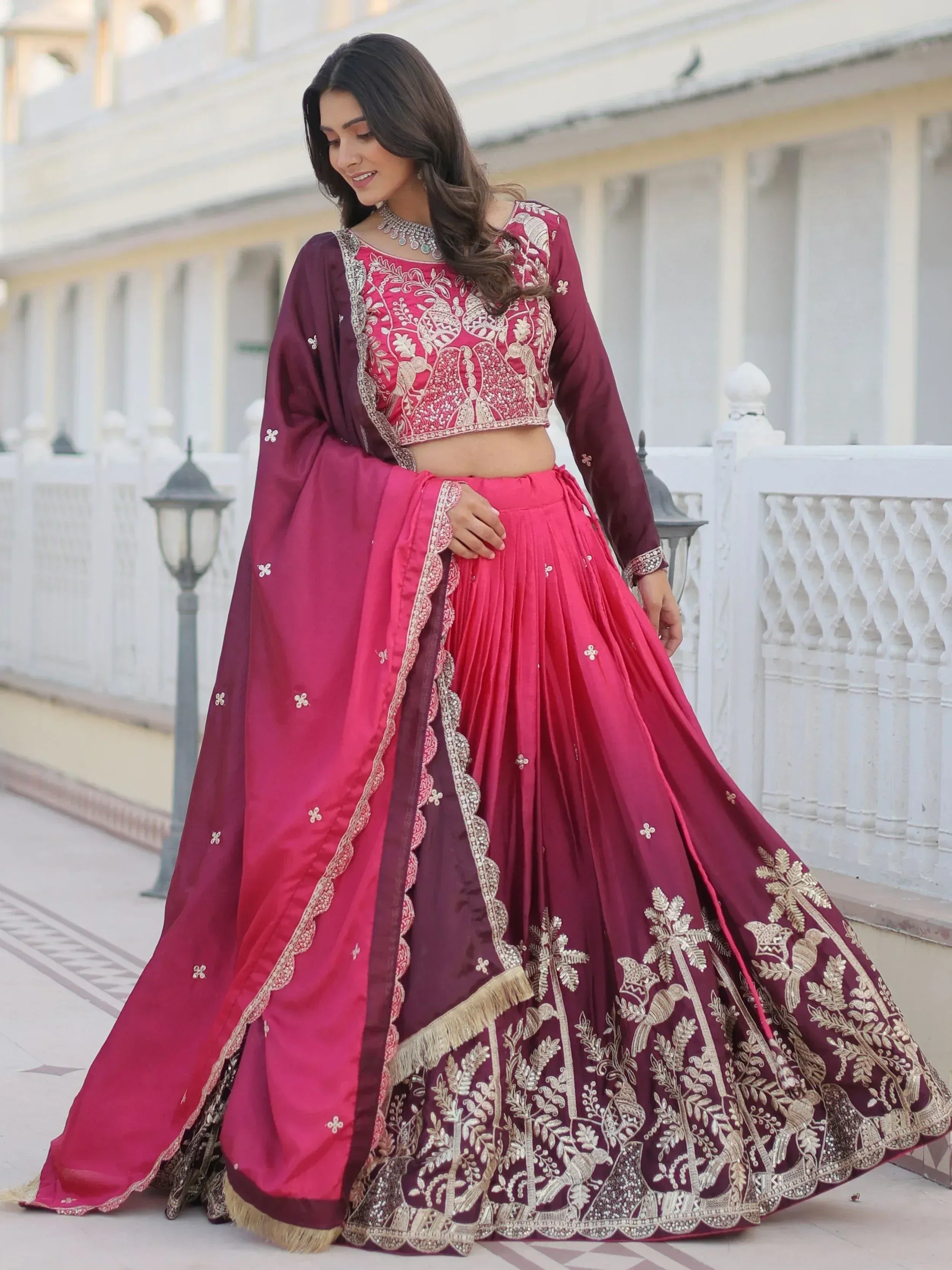 Elegant maroon and pink embroidered lehenga choli with gold detailing, perfect for Indian weddings and festive occasions.