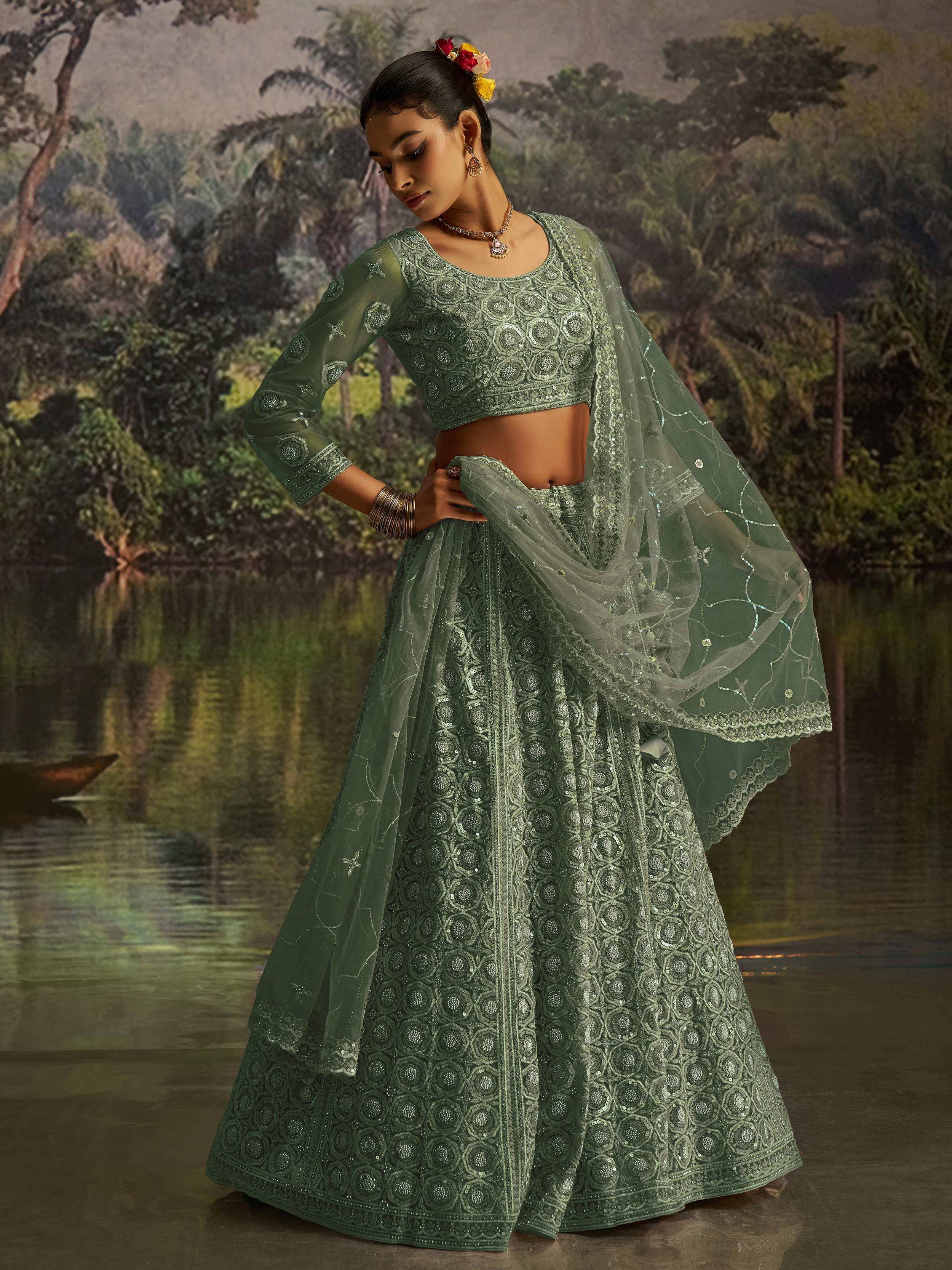 Emerald green designer lehenga choli with intricate embroidery and sheer dupatta, perfect for Indian ethnic wear occasions.
