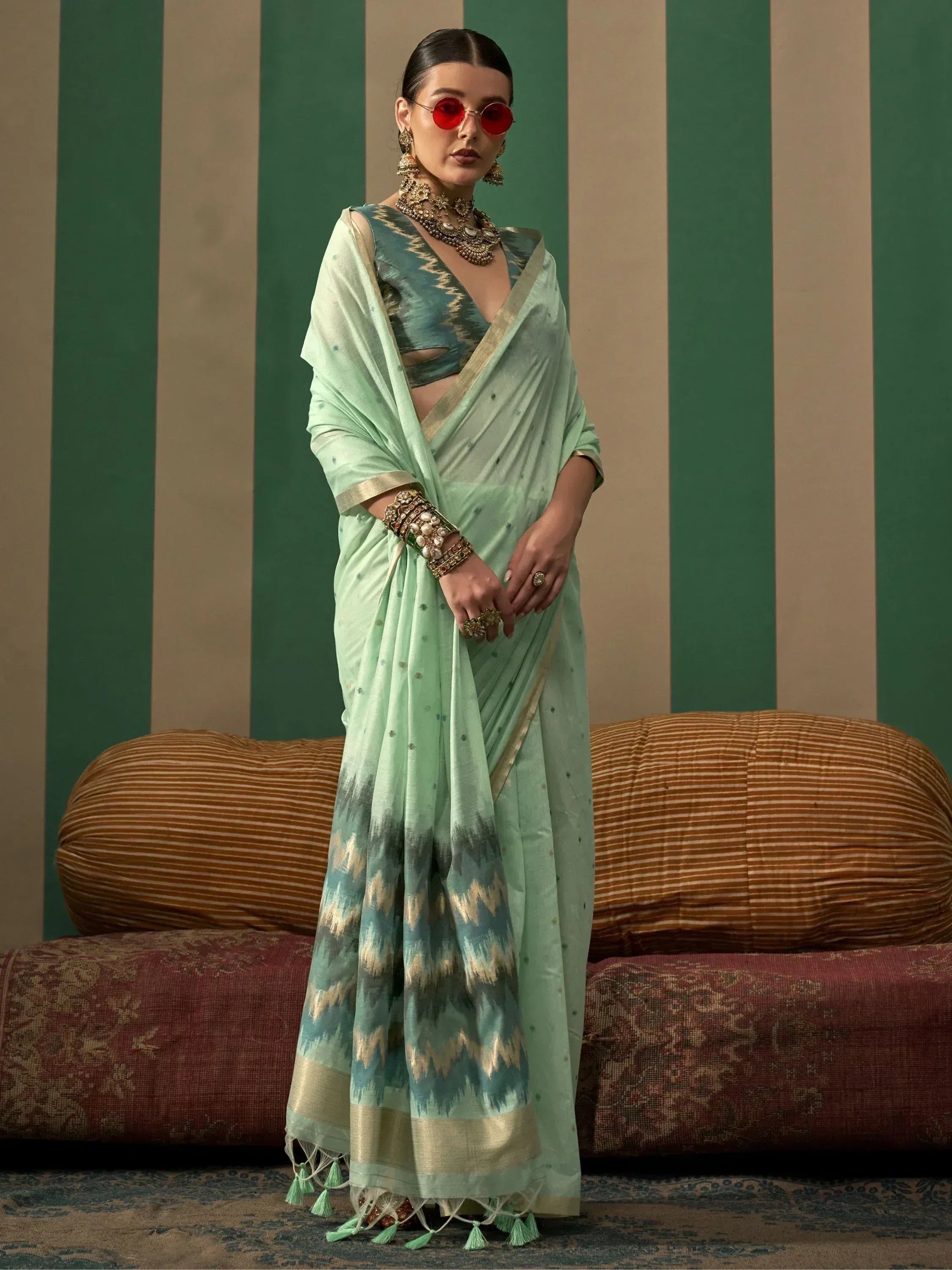Mint green ikat saree with gold border and tassels, paired with matching blouse and traditional jewelry
