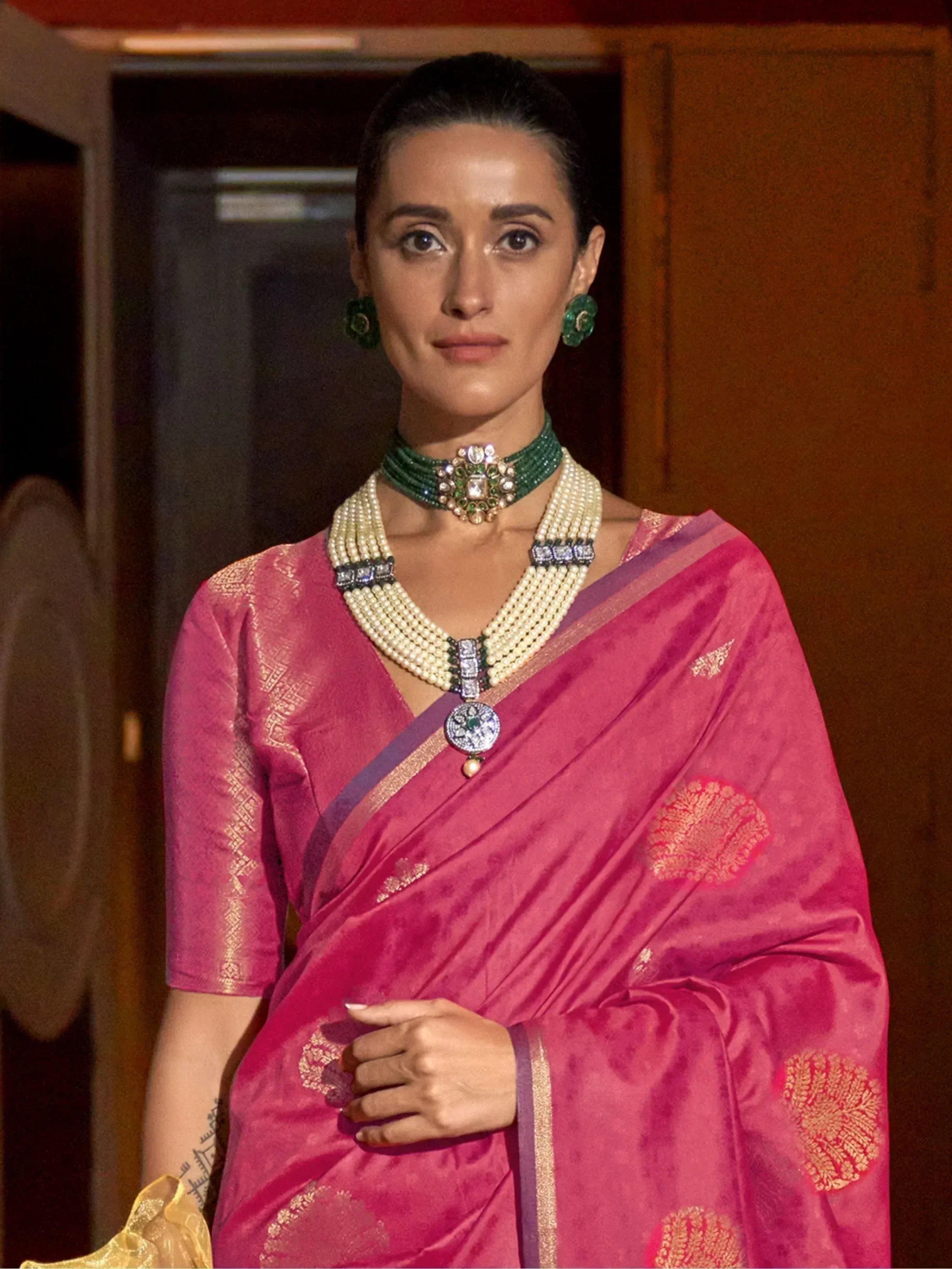 Woman in pink silk saree with gold embroidery, pearl and emerald jewelry, Indian ethnic wear