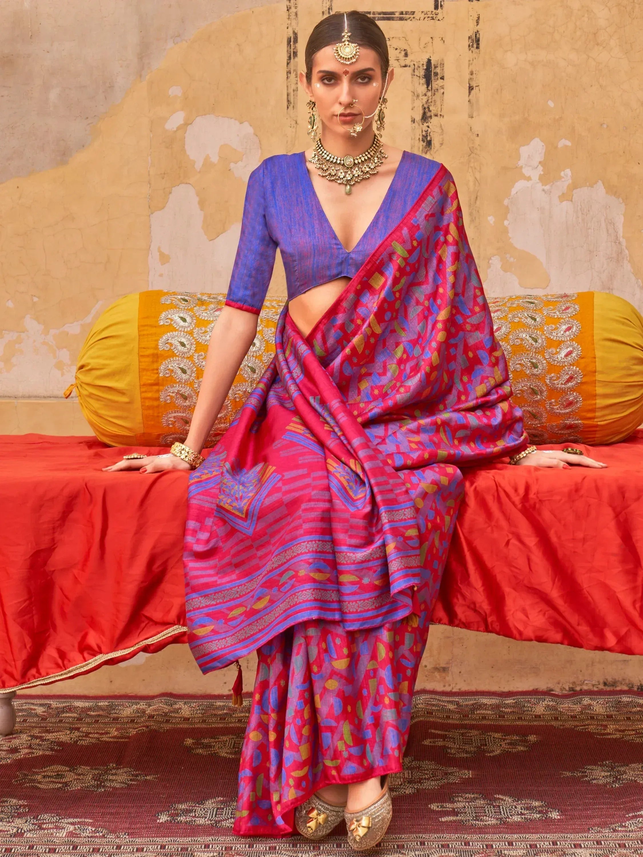 Woman in vibrant pink and blue printed saree with matching blouse, traditional Indian ethnic wear